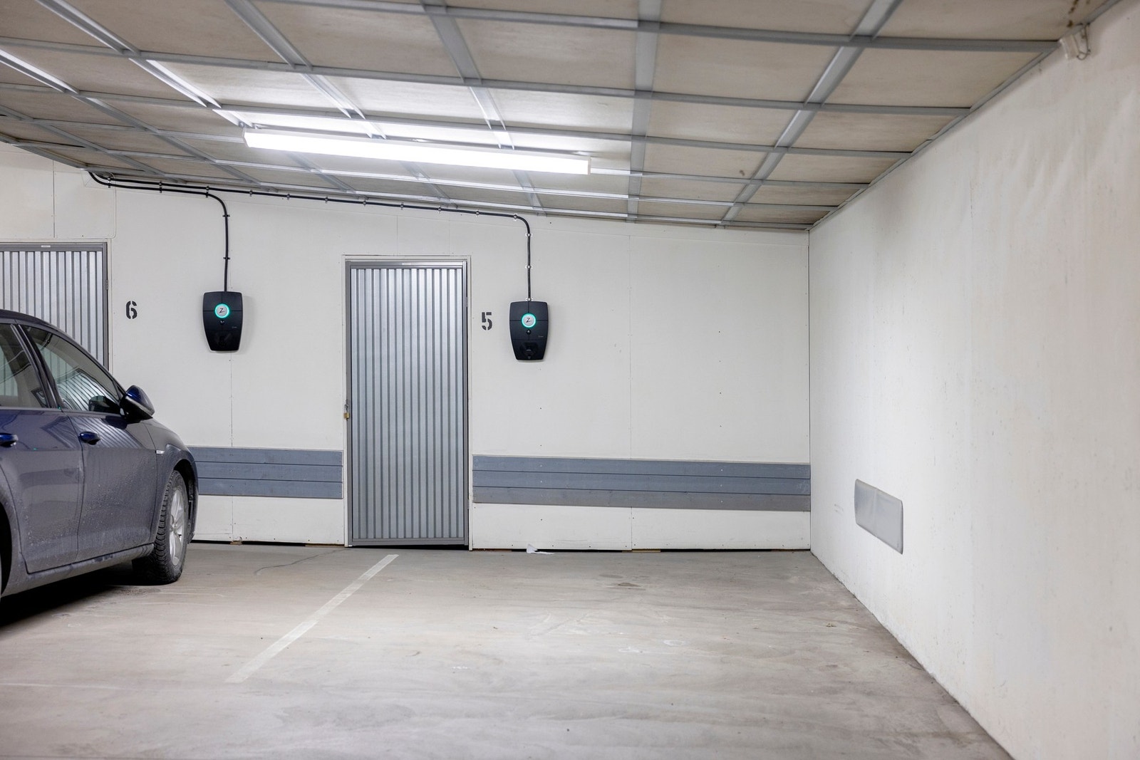 Parkeringsplass til en bil med el-billader. Romslig bod i bakkant av garasjeplassen. Galleribilde