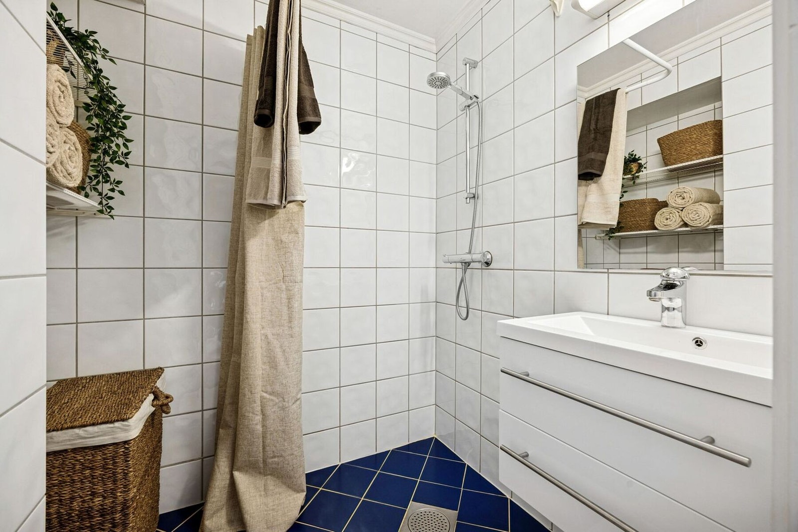 Flislagt bad med elektriske varmekabler i gulvet og en funksjonell innredning. Galleribilde