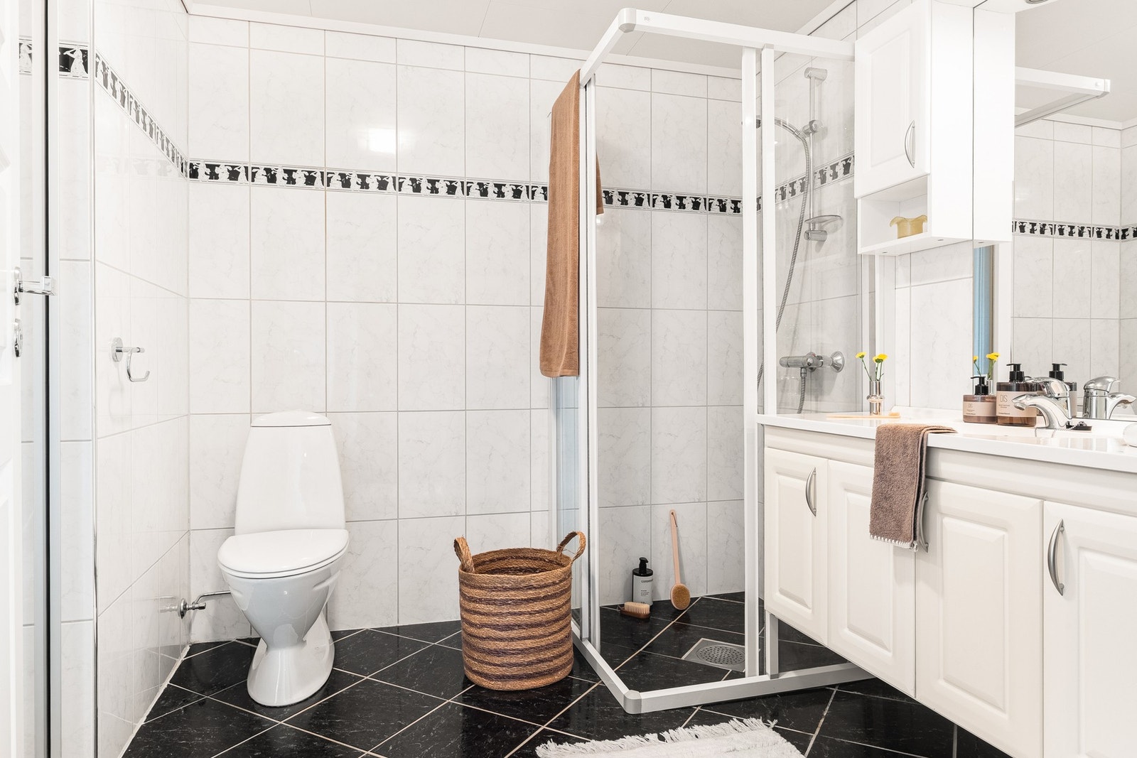 Badet er innredet med dusjhjørne, toalett, servant med underskap og speil. Galleribilde