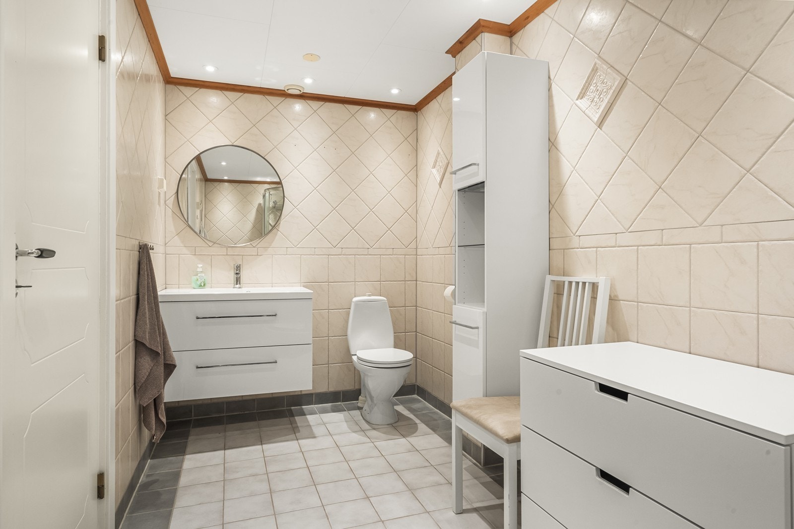 Flislagt bad i underetasjen med servantinnredning, toalett og god skapplass. Galleribilde