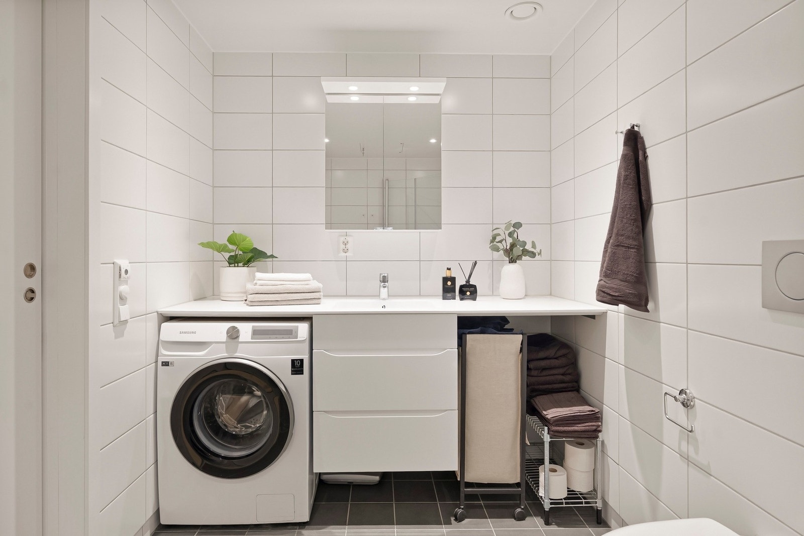 Baderommet er utstyrt med dusjhjørne, vegghengt toalett og servant med tilhørende servantskap og skuffer. Galleribilde