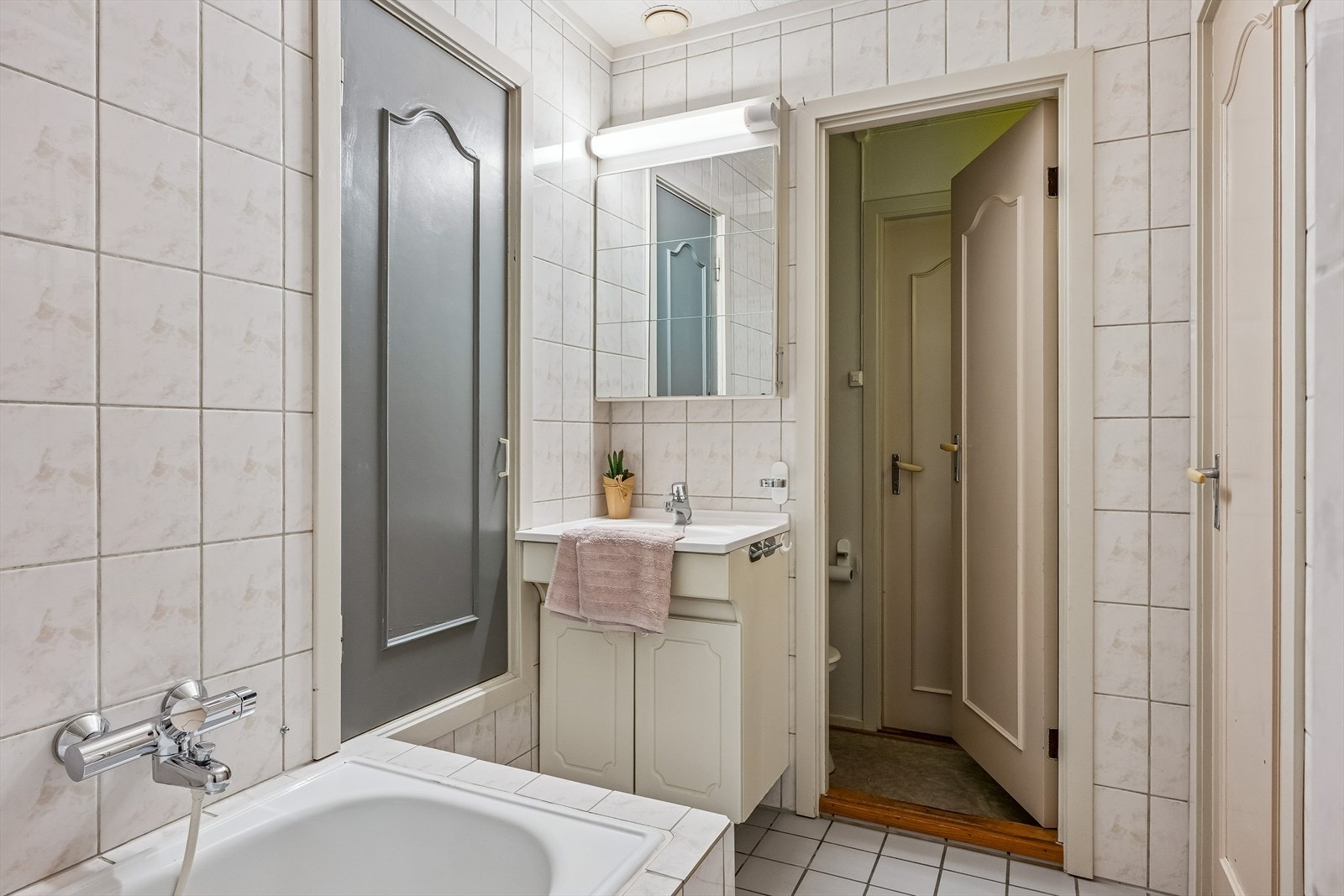 Bad med nytt dusjbatteri, armatur 2026. Bad har badekar og egen dusj. Grå dør inn til tørkerom Galleribilde