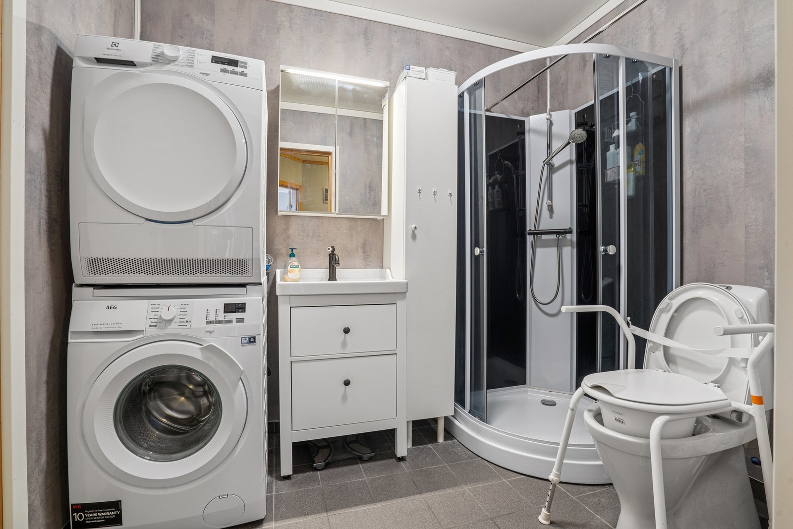 Bad på 5 kvm med gulvvarme. Badet er utstyrt med dusjkabinett, mekanisk avtrekk, opplegg for vaskemaskin, servant, servantskap og wc. Galleribilde