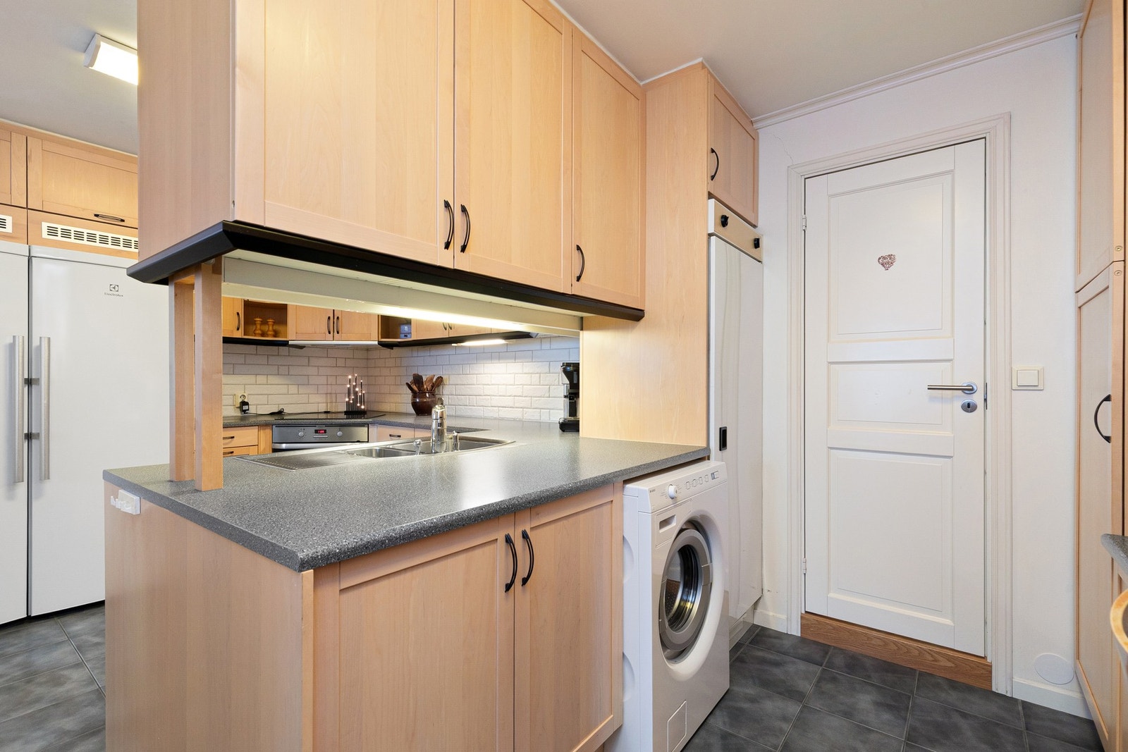 Kjøkken har grovkjøkken med opplegg for vaskemaskin Galleribilde