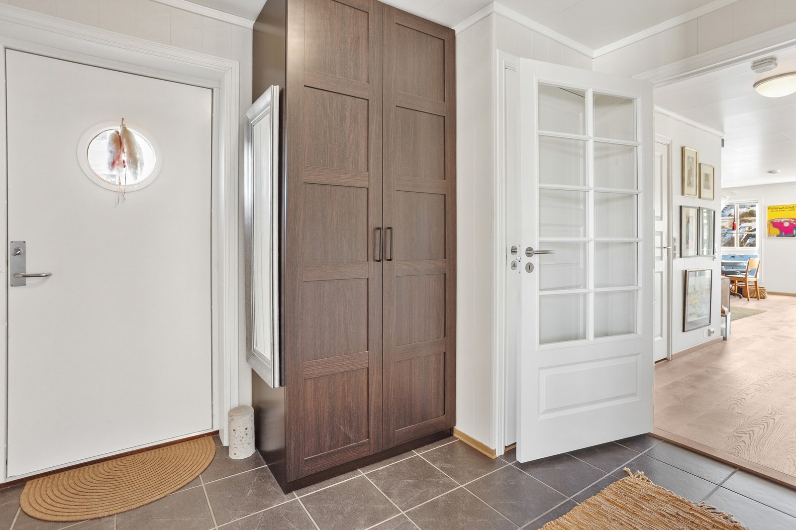 Flislagt entrè med garderobe og plass til å henge fra seg klær og sette sko. Varmekabler i gulv. Galleribilde