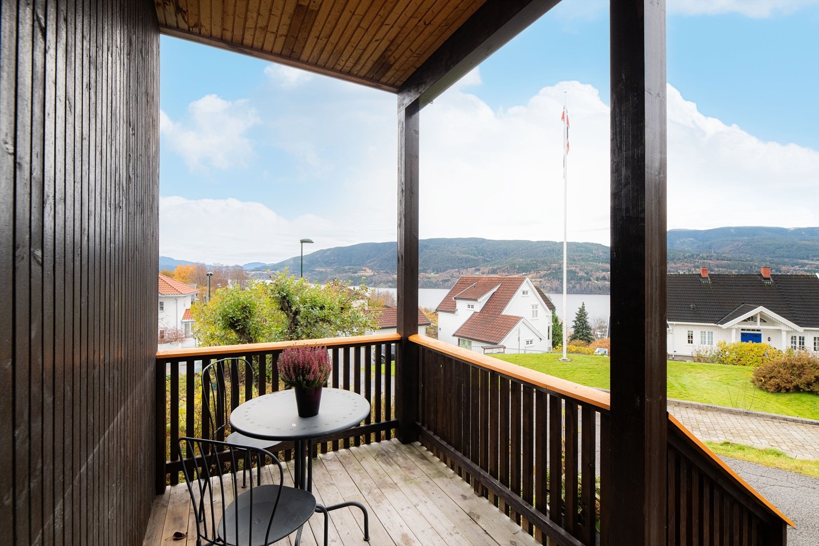 Boligen har et hyggelig, overbygget inngangsparti med plass for en sittegruppe, blomster og lykter. Galleribilde