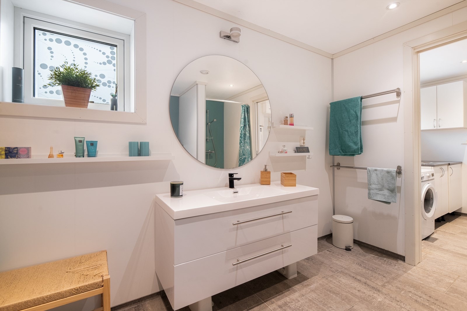 Badet har flis og varmekabler på gulv, baderomsplater på vegger og malt tak med spotter. Det er balansert ventilasjon. Galleribilde