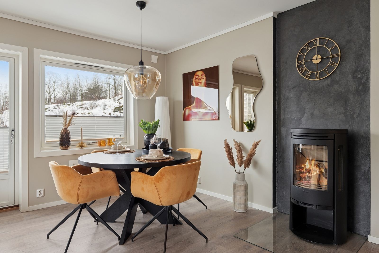 Stua er utstyrt med peis, og den sortmalte pipemuren skaper en fin kontrast i rommet. Galleribilde