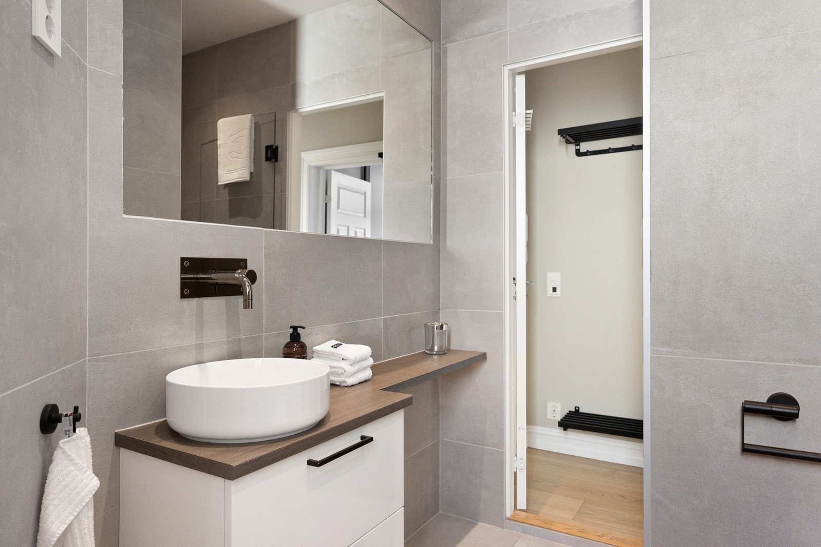 Her er det store, grå fliser på veggene, downlights i himlingen og lyse fliser på gulv med gulvvarme. Galleribilde