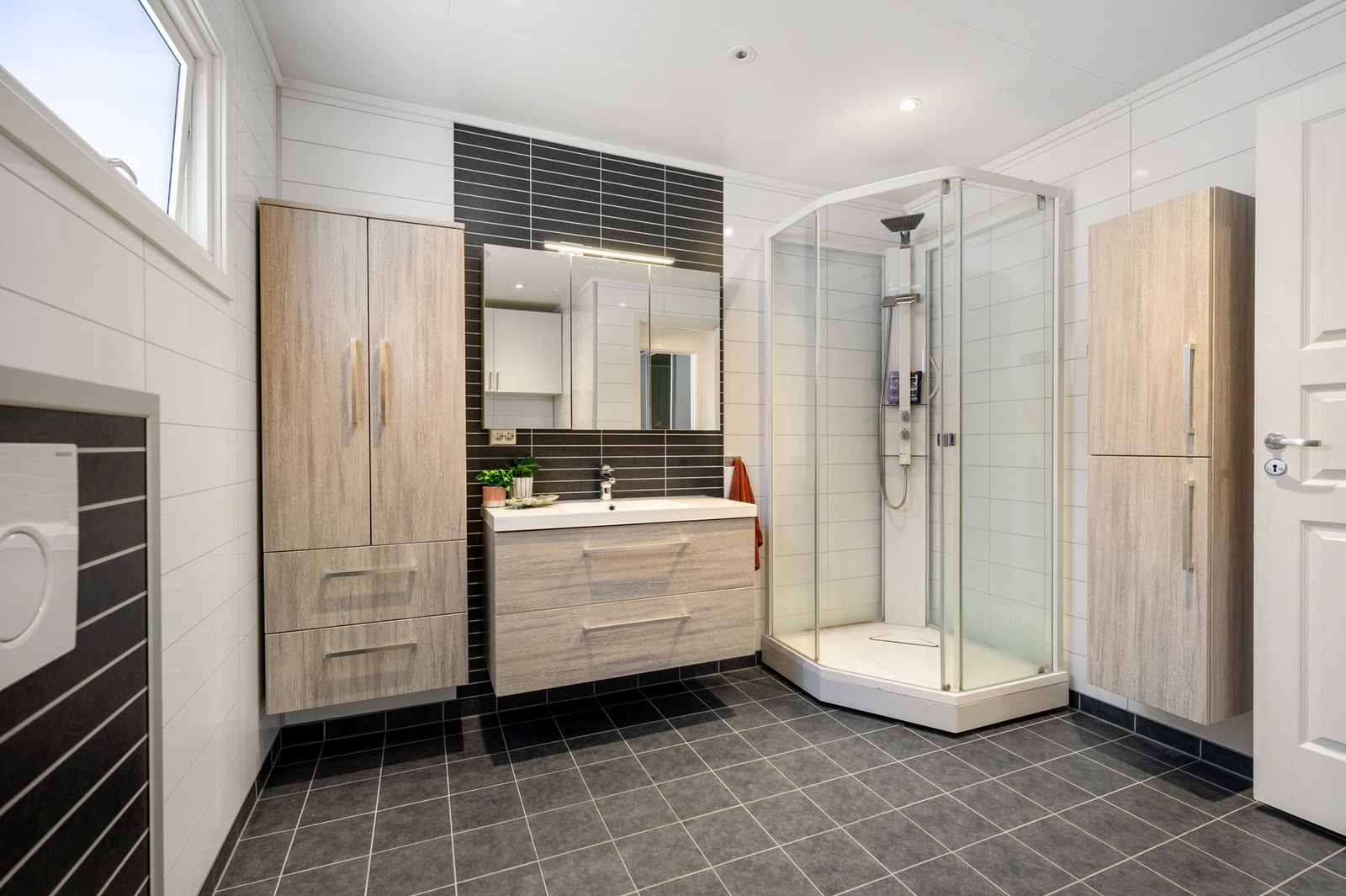 Meget praktisk med vegghengte innredninger og rikelig skapplass for håndklær og baderomsartikler Galleribilde