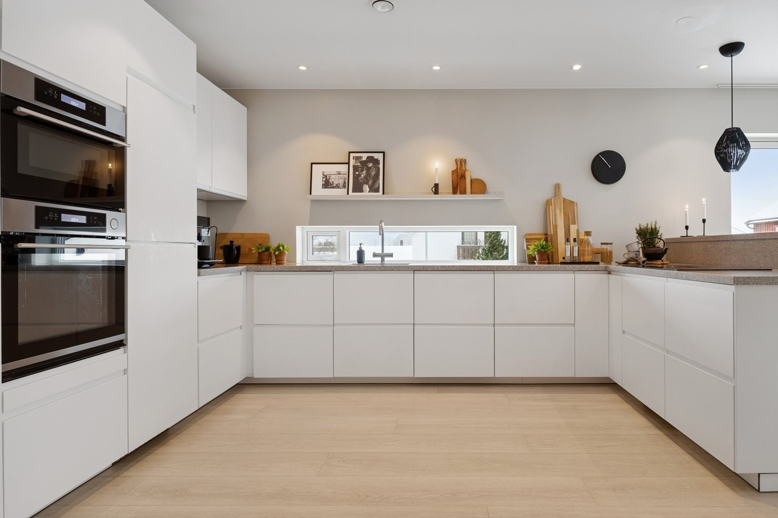 Kjøkkeninnredningen har slette fronter og en solid benkeplate i stein. Galleribilde