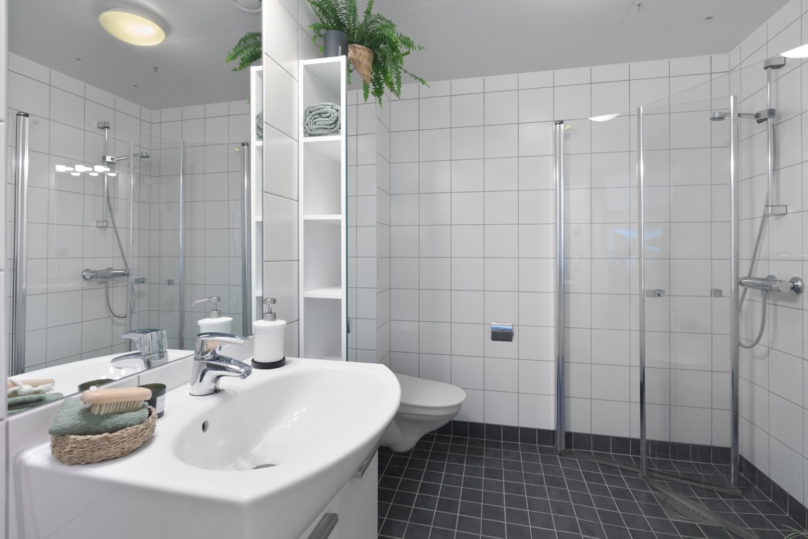 Leiligheten har en pent og flislagt bad med varme i gulvet. Galleribilde