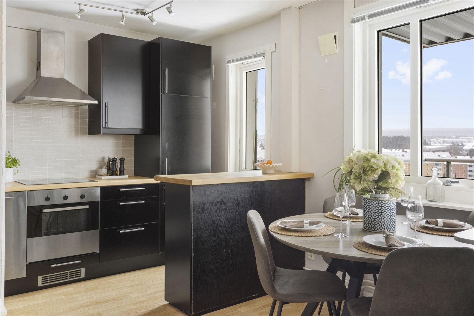 Kjøkkeninnredningen har glatte, folierte fronter og en benkeplate i tre som ble pusset ned og lakkert i 2026. Galleribilde