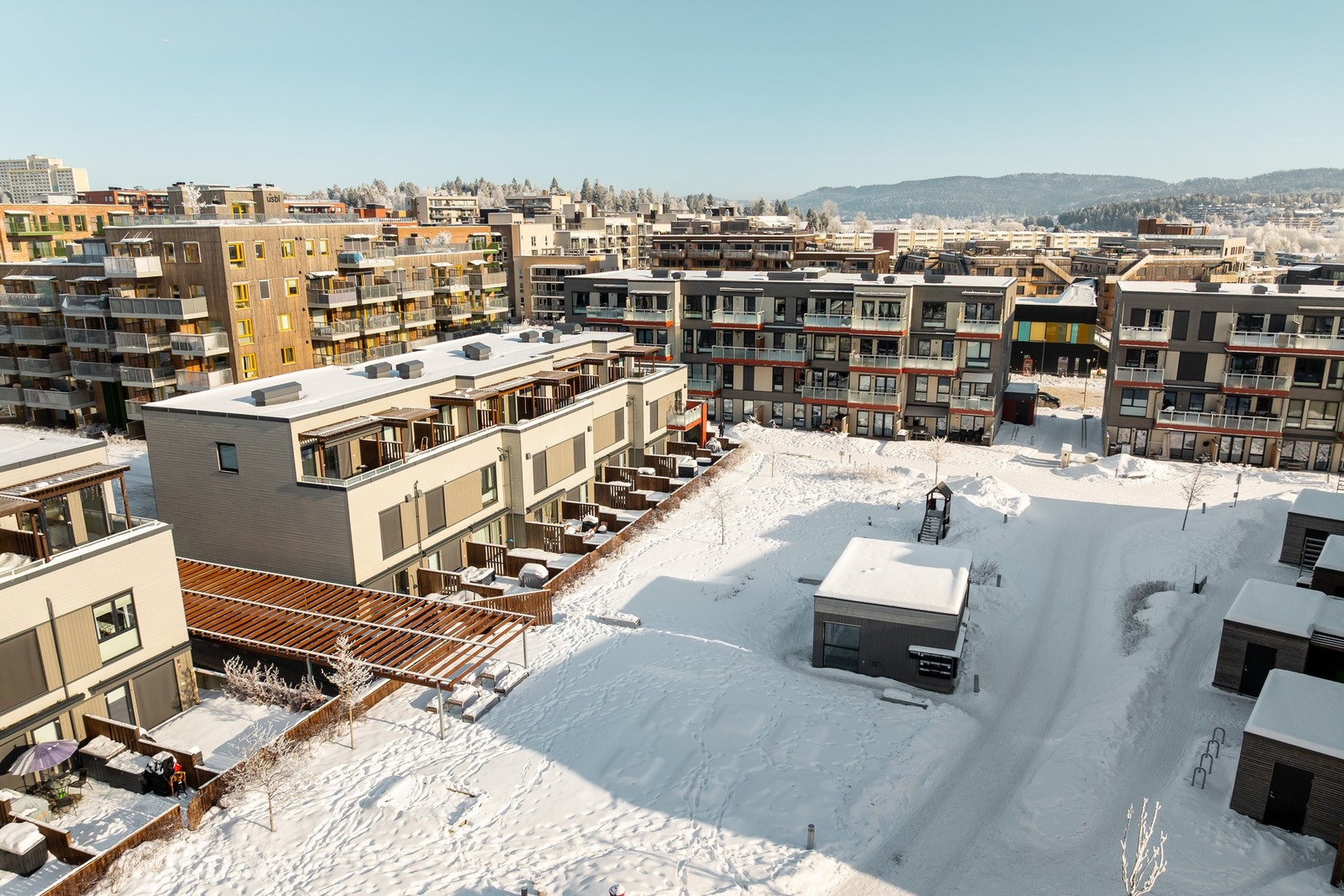 Fellestomten er pent opparbeidet med gressplen, prydbusker og asfalterte internveier. Galleribilde