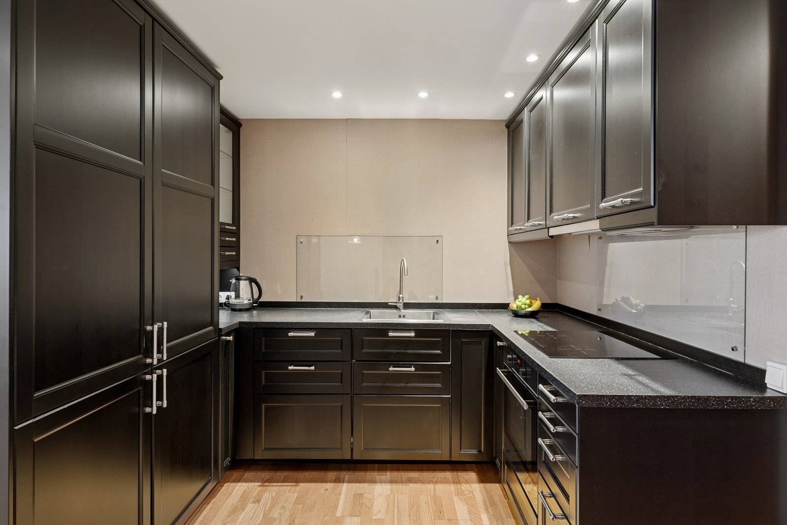 Lyst og praktisk kjøkken med moderne, mørke fronter og god benkeplass. Galleribilde