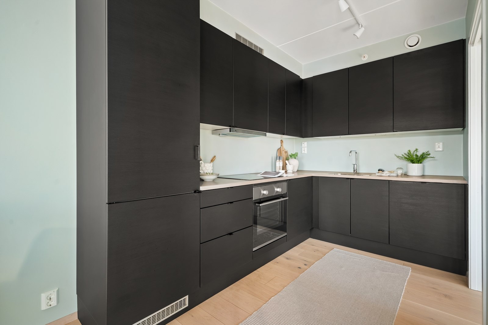 Kjøkkenet er utstyrt med innfelt komfyr med platetopp og ventilator over kokesonen. Galleribilde