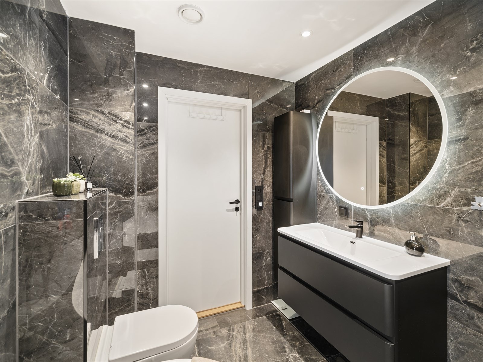 Badet er utstyrt med vegghengt toalett og komfortable varmekabler i gulvet Galleribilde