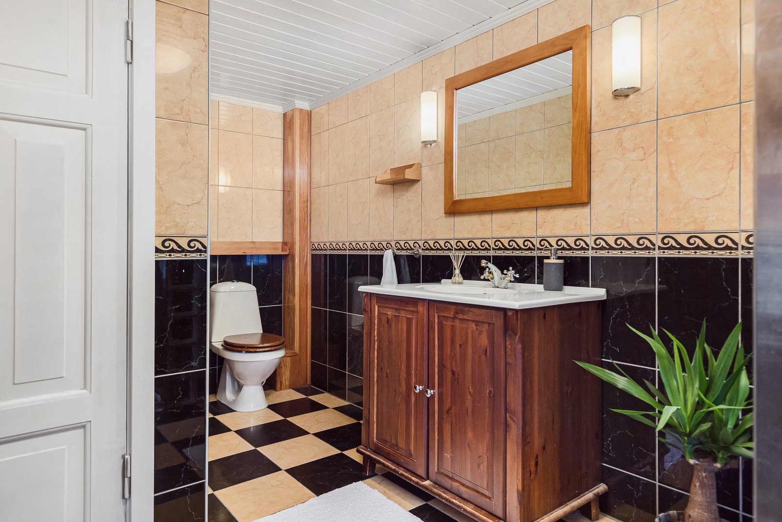 Badet er utstyrt med toalett, dusjhjørne og servant med servantskap. Galleribilde