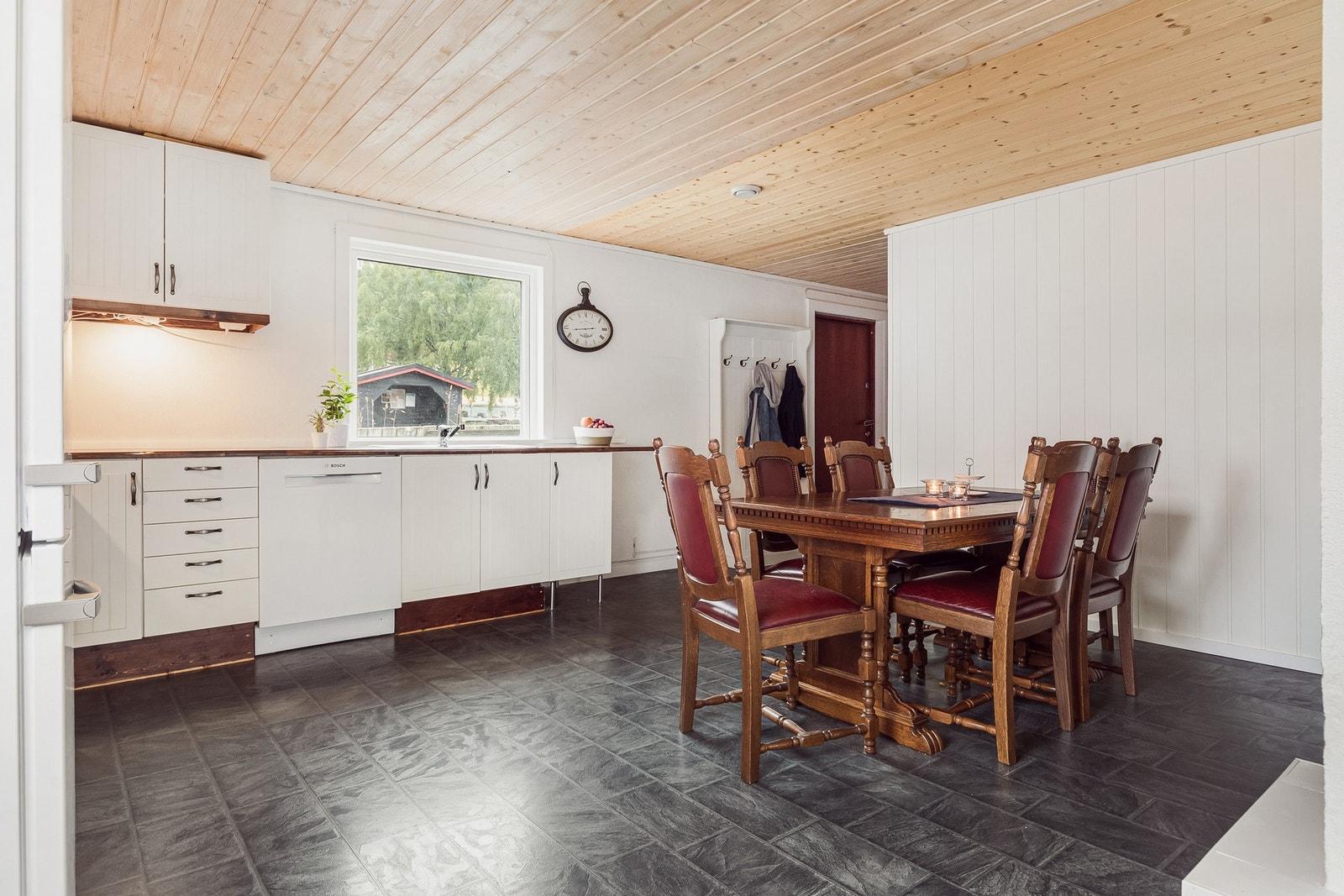 Hvit kjøkkeninnredning med folierte skrog med profilerte fronter og laminat benkeplate. Galleribilde