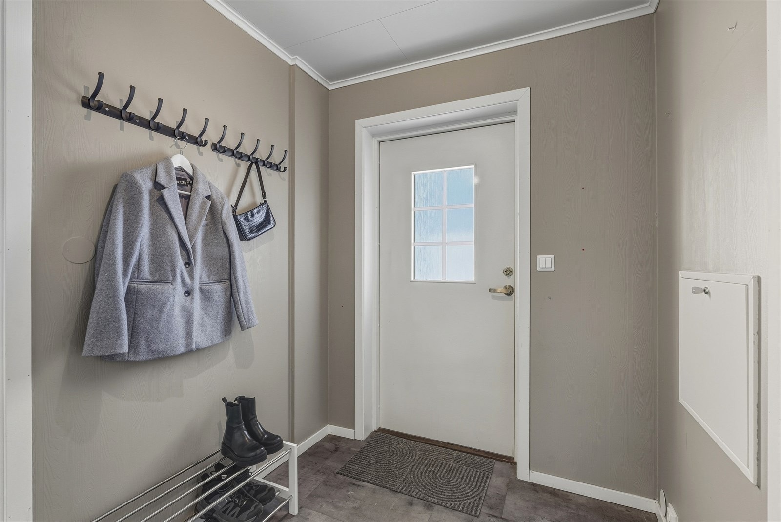 Entréen gir et flott førsteinntrykk av boligen, og har praktisk klikkvinyl på gulv og rom for flere oppbevaringsløsninger for yttertøy og sko. Galleribilde