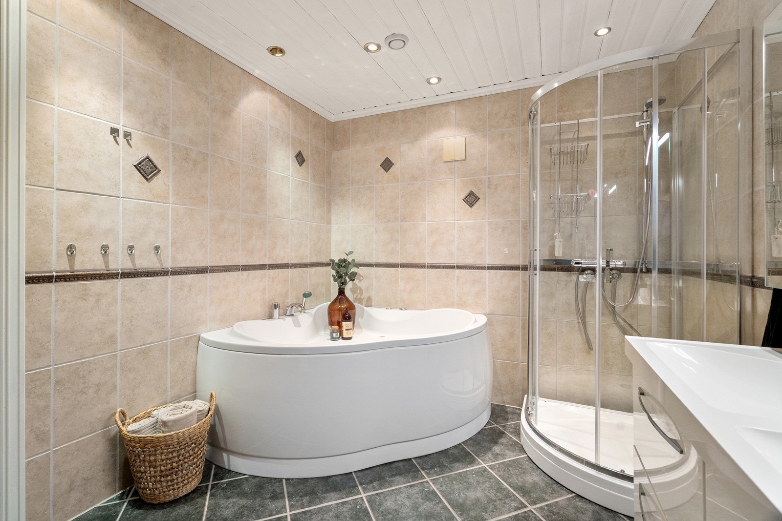 Rommet har innredning med to nedfelte servanter, toalett, dusjkabinett og badekar. Galleribilde