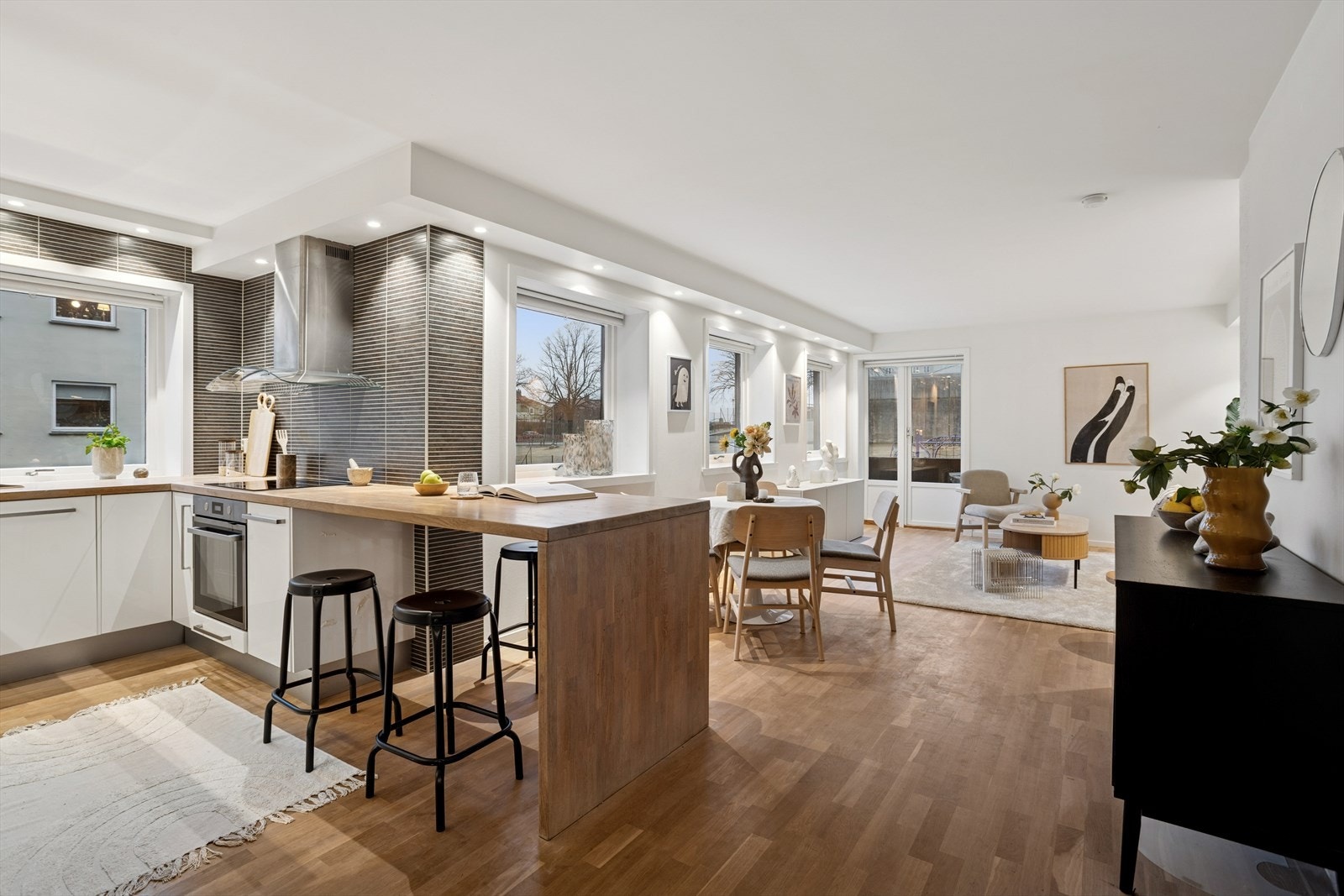 Den praktiske kjøkkenøya fungerer som et naturlig og elegant skille mellom stuen og kjøkkenet, samtidig som den åpner for en sosial og funksjonell romløsning. Galleribilde