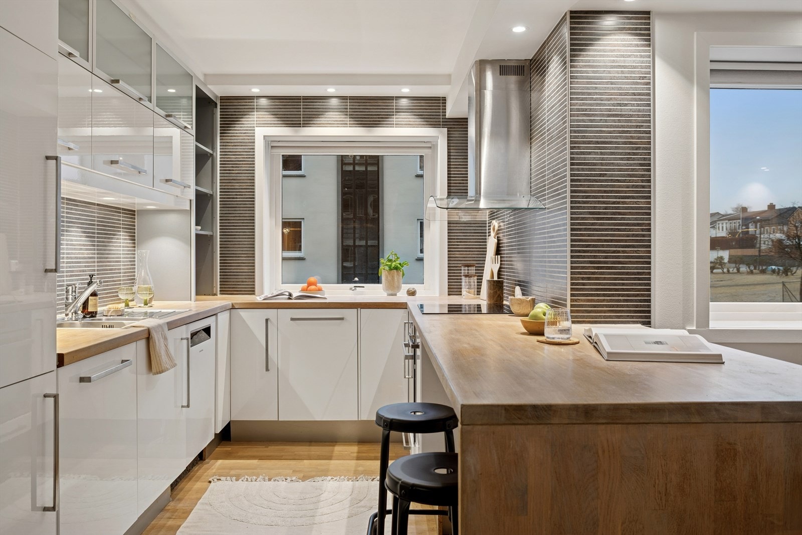 Kjøkkenet har fliser over benkeplatene, rundt vinduet og på veggene, noe som både gir et stilrent uttrykk og gjør overflatene enkle å holde rene. Galleribilde