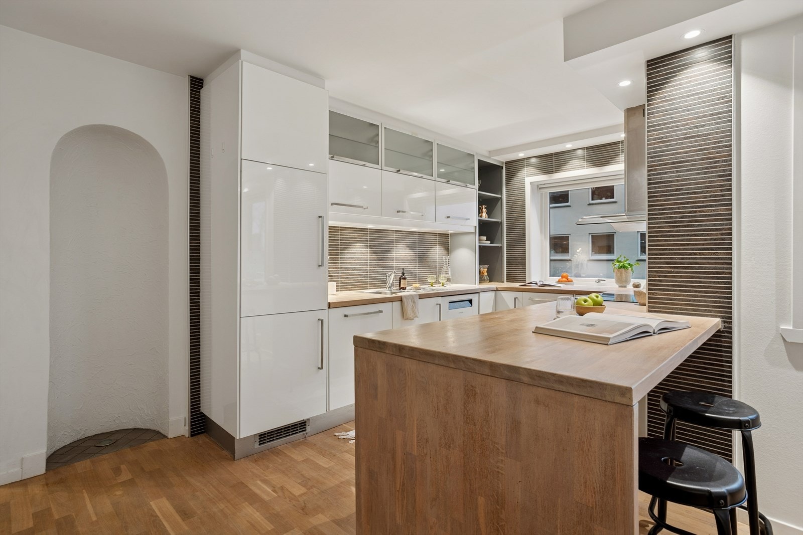 Kjøkkenøya har god plass til fire barstoler, noe som gjør den til et naturlig samlingspunkt i rommet. Her kan du kombinere matlaging med sosialt samvær, servere en rask frokost eller skape en hyggelig plass for gjester mens du står på kjøkkenet. Galleribilde