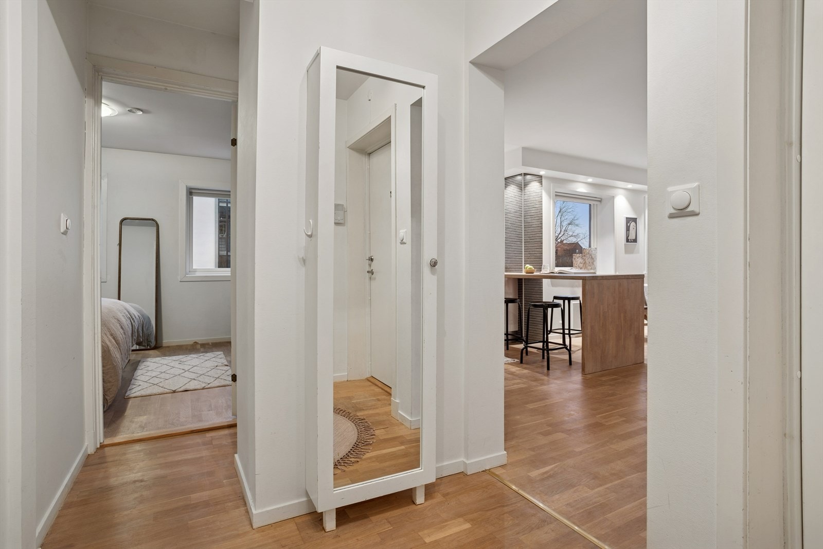 Fra entréen er det direkte tilgang til både baderom og leilighetens to soverom, før du ledes videre inn i en lys og åpen stue- og kjøkkenløsning som binder oppholdsrommene sammen på en praktisk og innbydende måte. Galleribilde