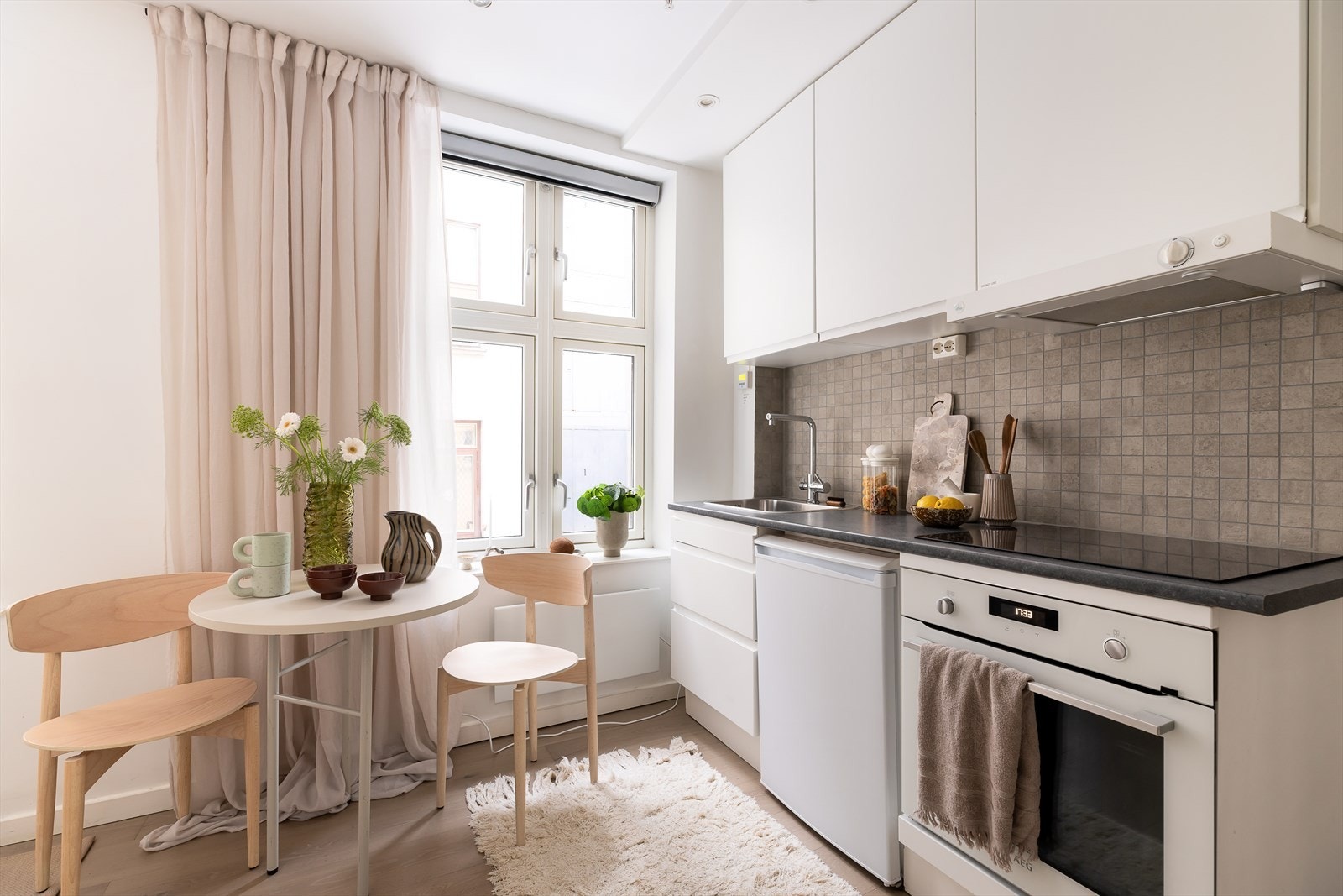 Pen kjøkkeninnredning med integrert kjøleskap, komfyr og platetopp. Galleribilde