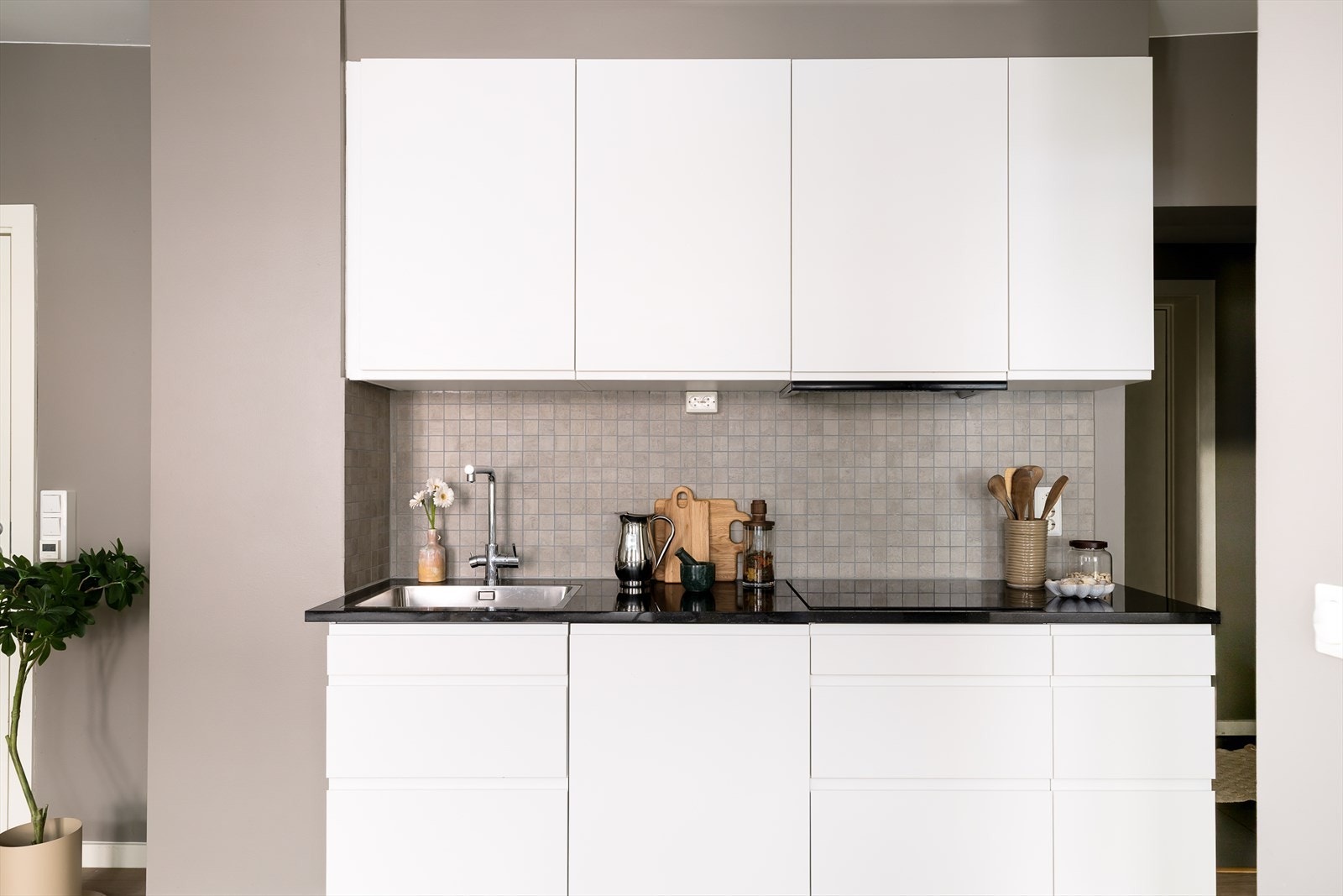 Lekkert og tidsløst kjøkken i dansk design fra AUBO. Kjøkkeninnredning med slette fronter og benkeplate av stein. Galleribilde