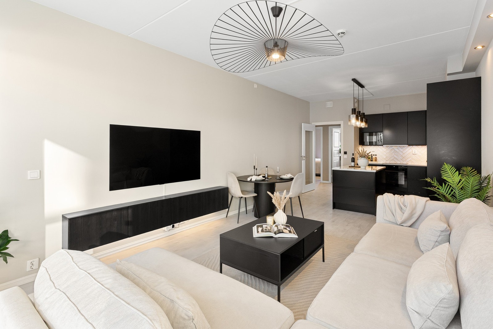 Oppholdsrommet er i en åpen stue- og kjøkkenløsning, noe som gir et sosialt allrom. Galleribilde