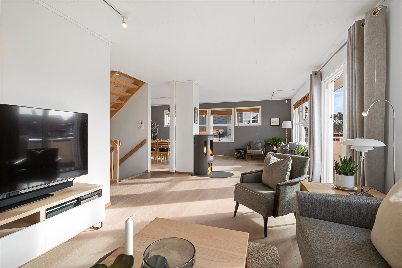 Lys og luftig vinkelstue med enstavs eikeparkett på gulv og malte vegger i tidsriktige farger Galleribilde