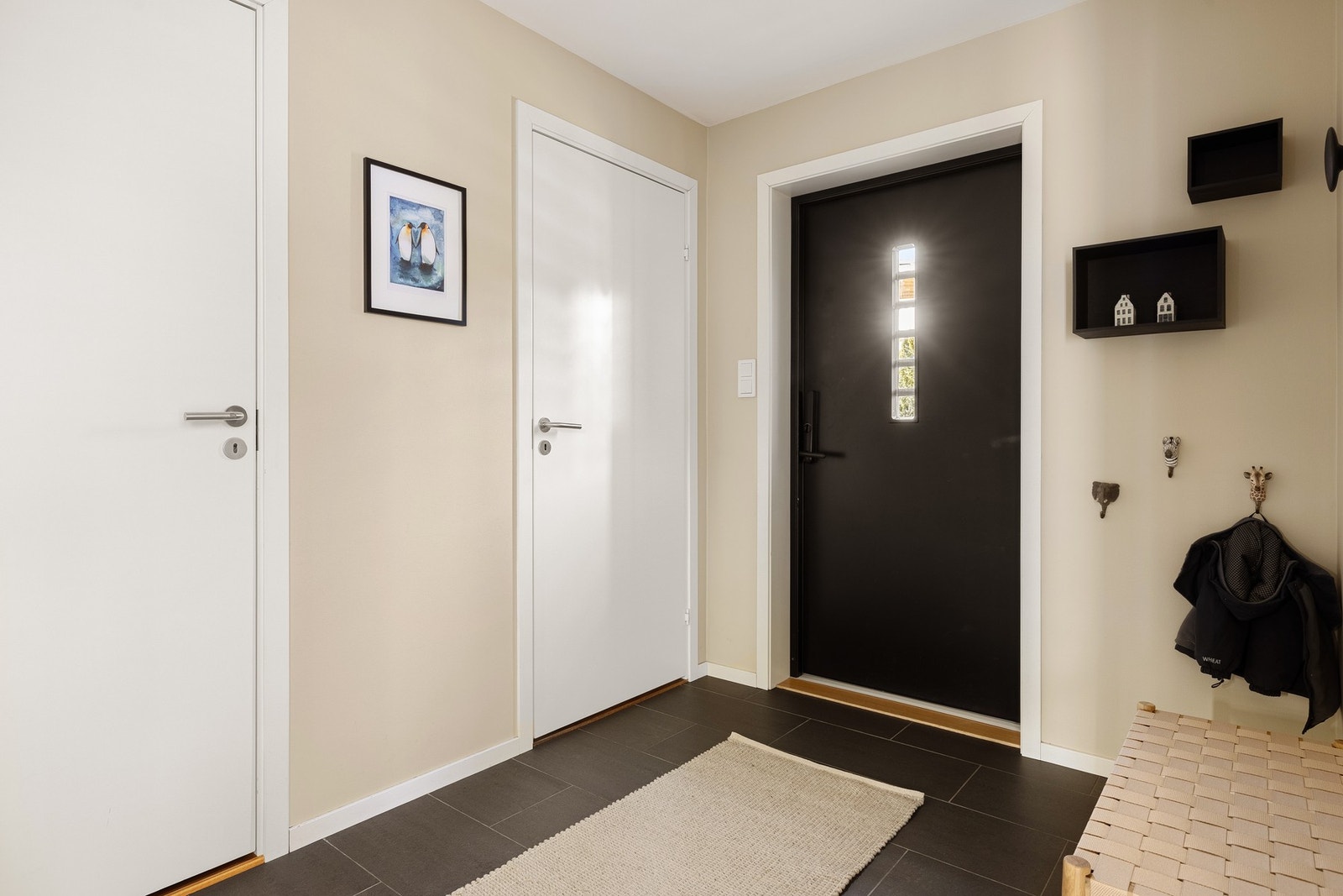 Her er det fliselagt på gulv og en skyvedørsgarderobe for godt med oppbevaringsplass til yttertøy og sko. Galleribilde