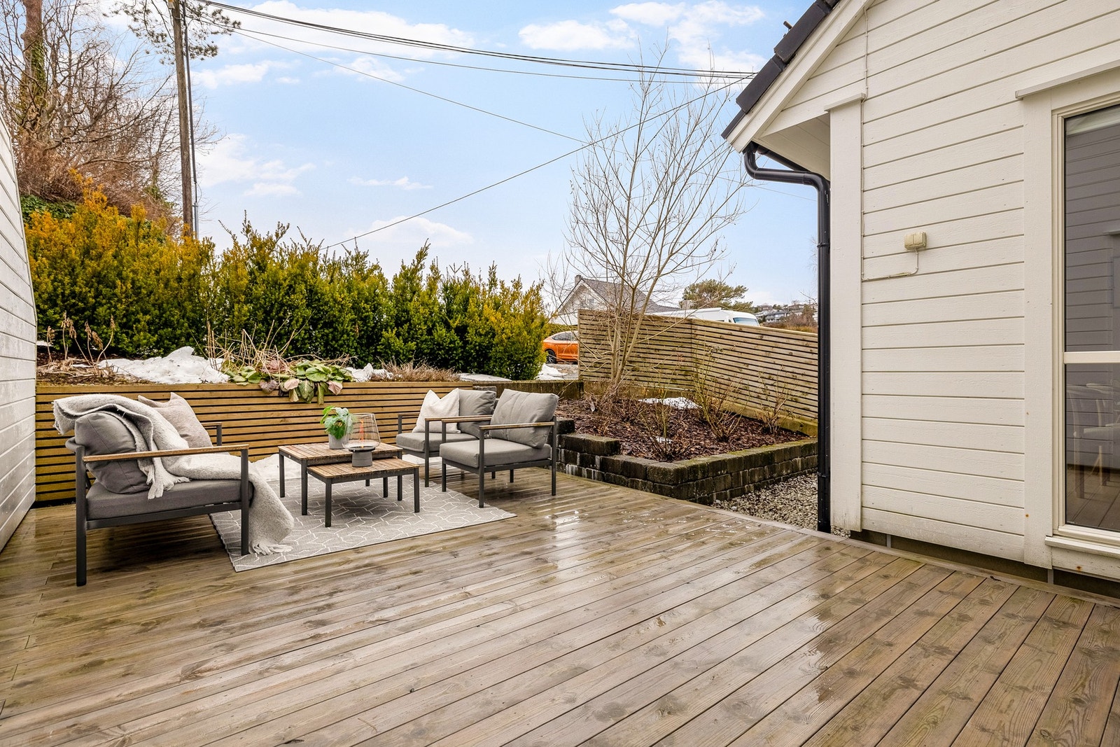 Terrassen er pent rammet inn med beplantning og rekkverk av spiler. Galleribilde