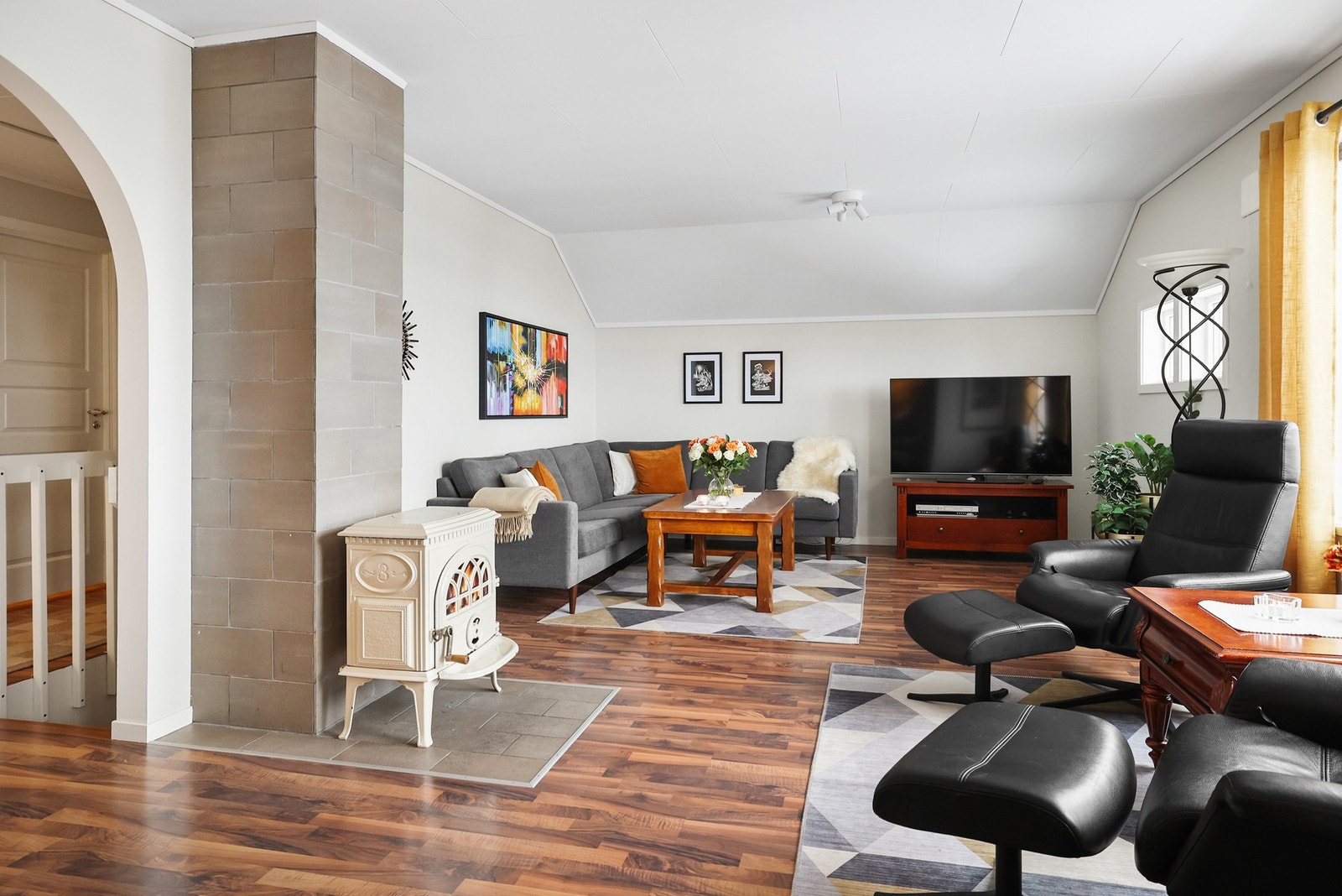 Her er det en naturlig plassering for en sofagruppe med tilhørende møblement, og en vedovn sørger for ekstra varme og hygge på kjølige dager. Galleribilde