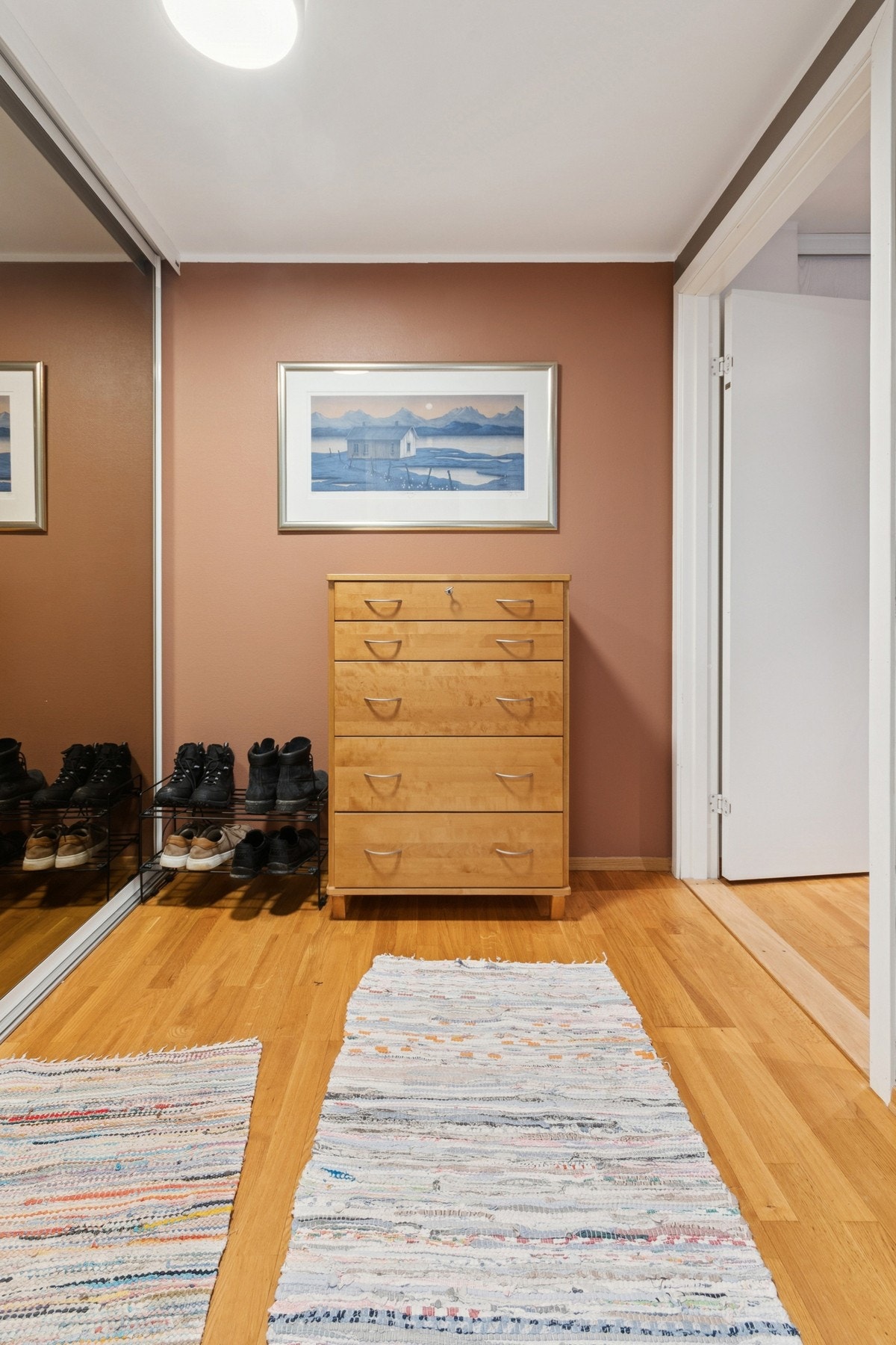 Romslig entré med integrert skyvedørsgarderobe med glassdører, der det er god plass til oppbevaring av yttertøy. Galleribilde