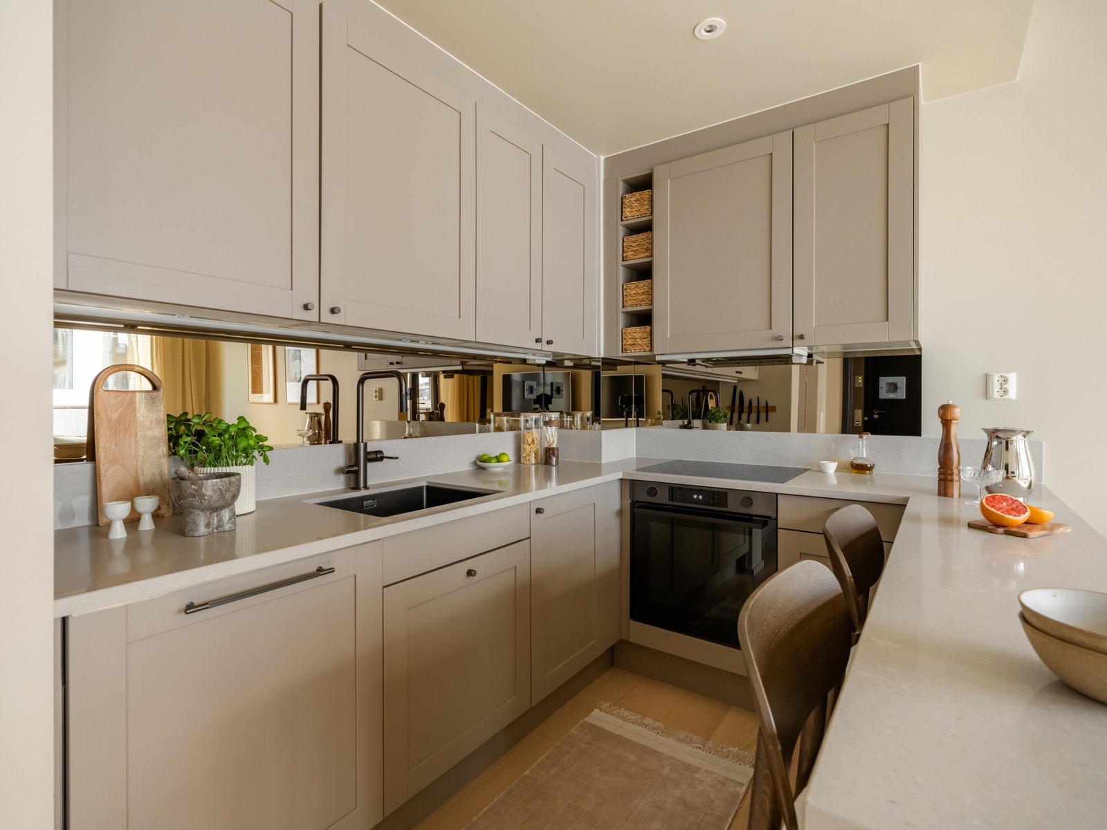 Kjøkkenet er delikat og innbydende med et flott speil montert på veggen over kjøkkenbenken. Dette skaper en eksklusiv følelse og ekstra dybde. Galleribilde