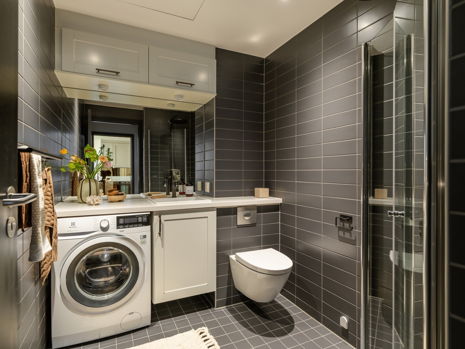 Badet er innredet med dusjhjørne, vegghengt toalett, servantskap med innfelt servant og speil. Galleribilde