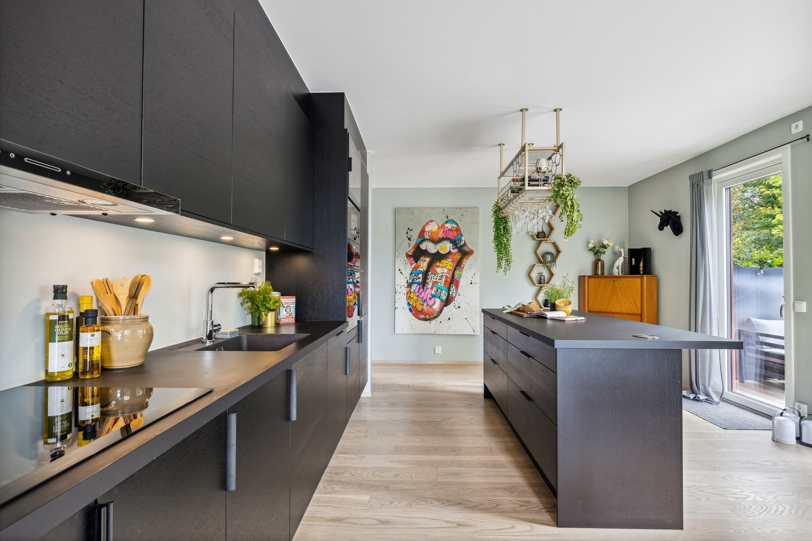 Kjøkkeninnredning fra Sigdal med slette mørke fronter. Komfyr, kjøleskap, vinskap og innebygd mikro medfølger. Galleribilde