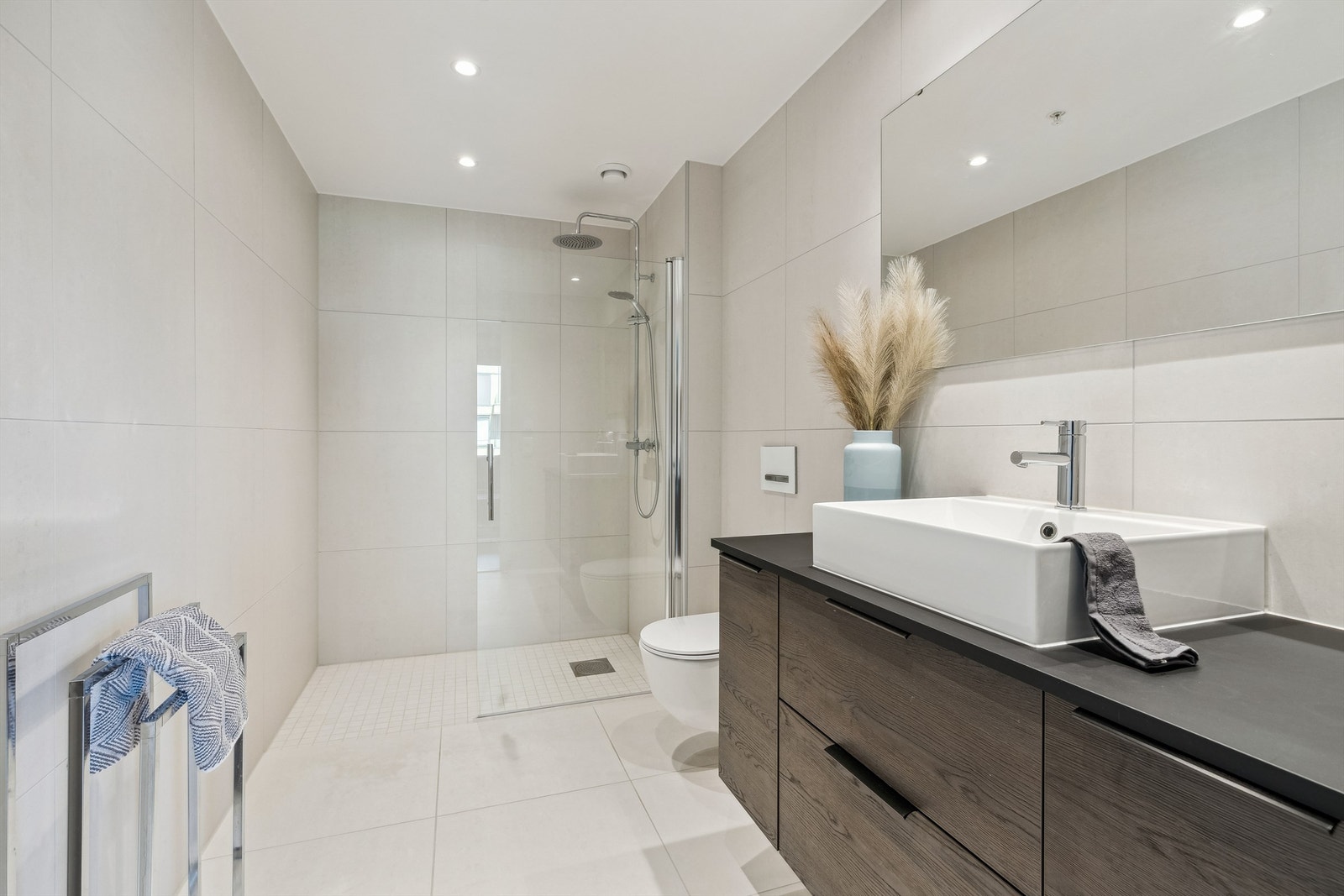 Lekkert bad i 2.etasje i gjennomført stil med store fliser, rainshower og vannbåren gulvvarme. Galleribilde