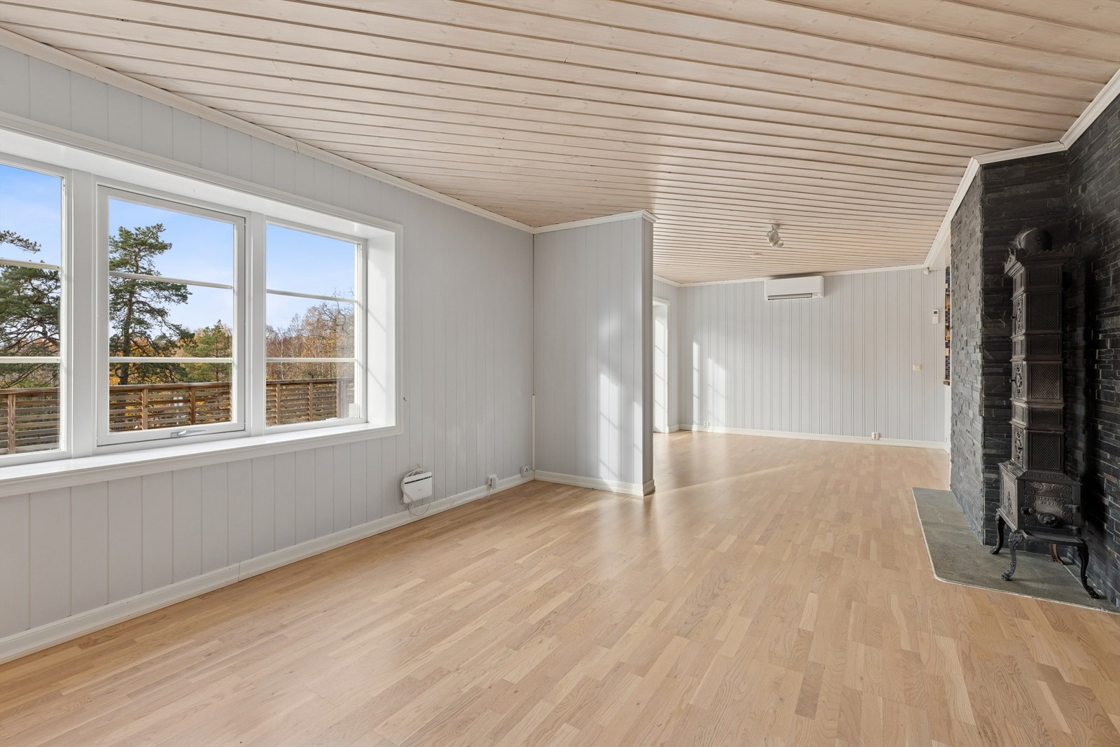 Stuen får godt med naturlig lys fra store vinduer. Hyggelig peisovn gir godt med varme på kalde dager samt en god atmosfære. Galleribilde