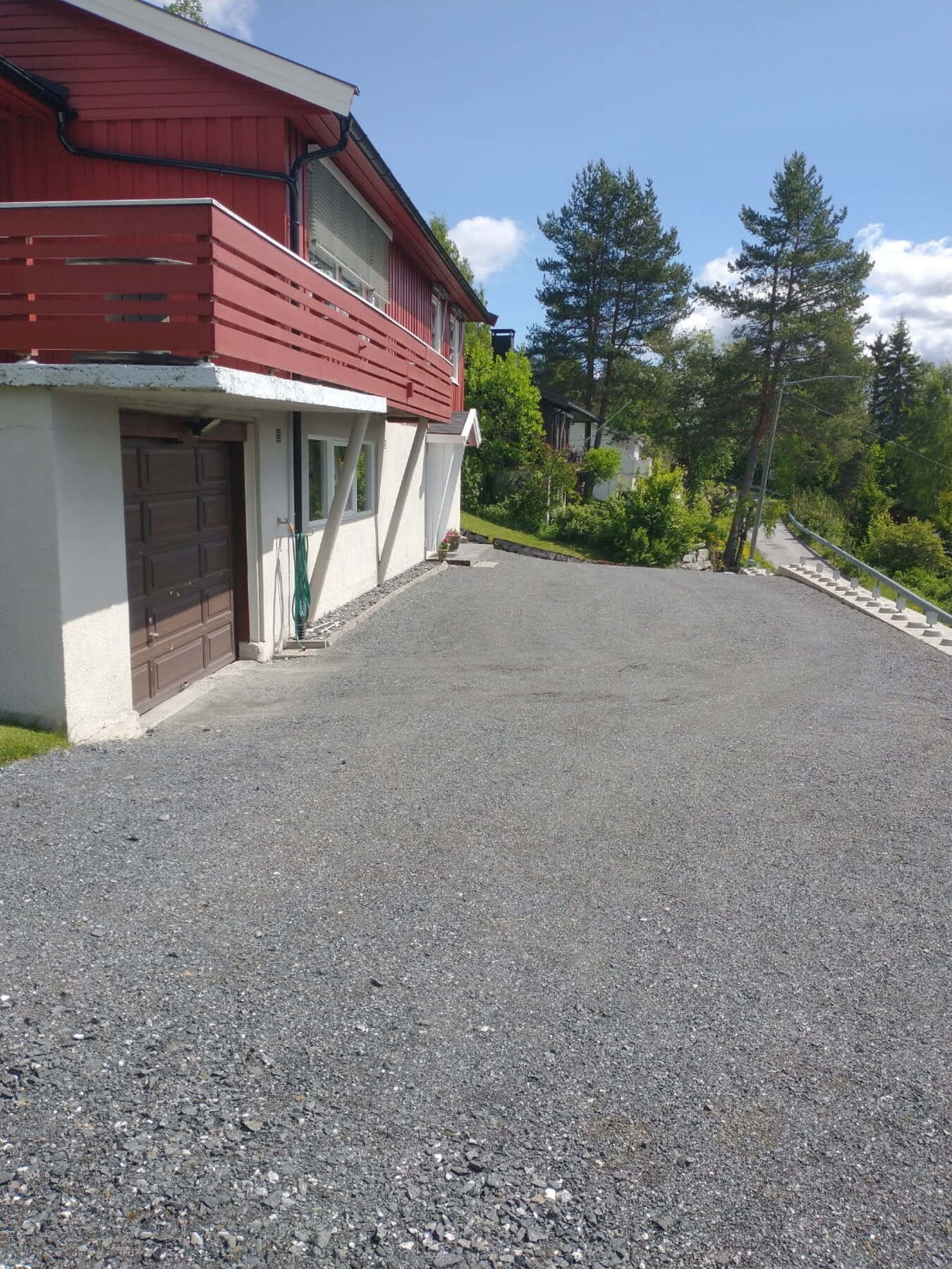 Gruset innkjørsel og parkering i garasje eller på eiendommen ellers. Galleribilde