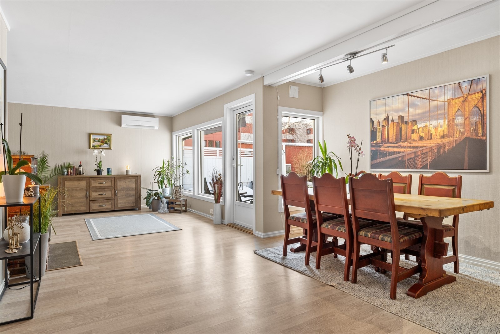 Rommet er smart inndelt i soner, noe som gir en god og funksjonell planløsning med tydelig skille mellom spiseplass og sofagruppe. Her er det rikelig med plass til både et romslig spisebord for hyggelige middager og en komfortabel sofakrok for avslapning. Galleribilde