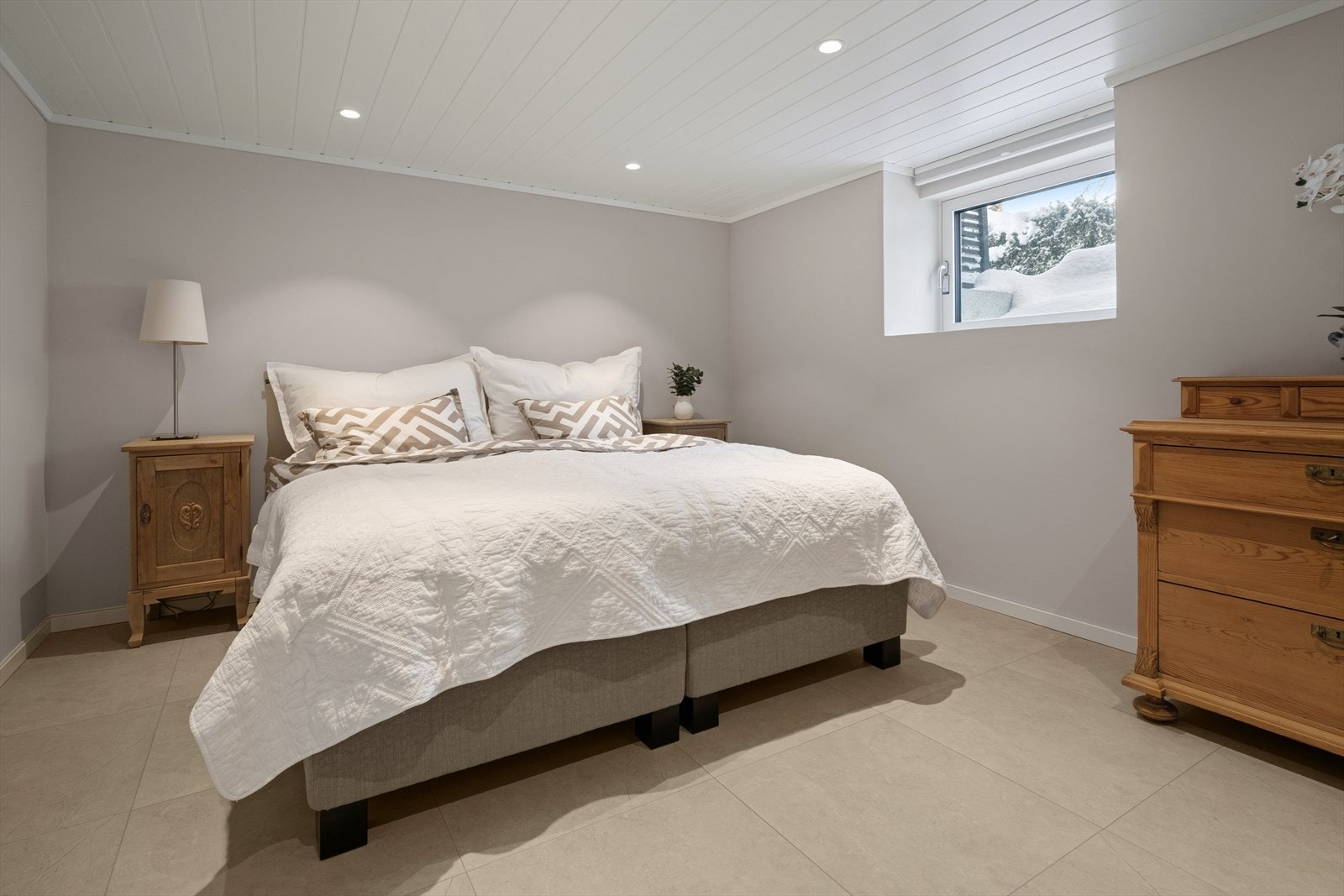 Soverommet i underetasjen er lunt og innbydende, med flislagt gulv og downlights i taket. Det bør tilrettelegges for rømning ut av vindu på soverom i u.etg som er 120 cm over gulvet (kravet er maks 100cm). Galleribilde