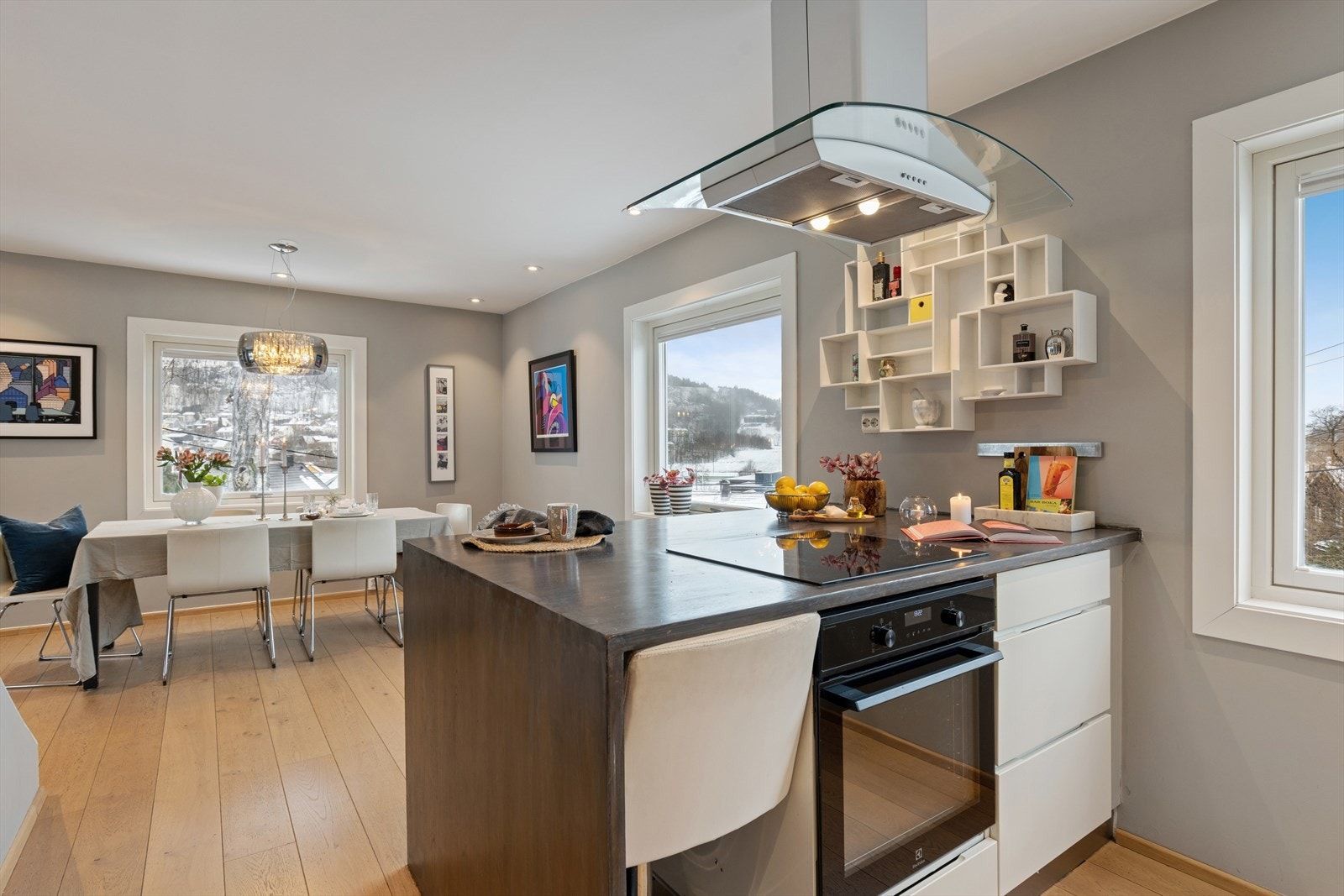 Den praktiske kjøkkenøyen fungerer som et naturlig samlingspunkt og gir ekstra arbeidsplass, samtidig som den markerer en elegant overgang mellom kjøkken og stue. Galleribilde