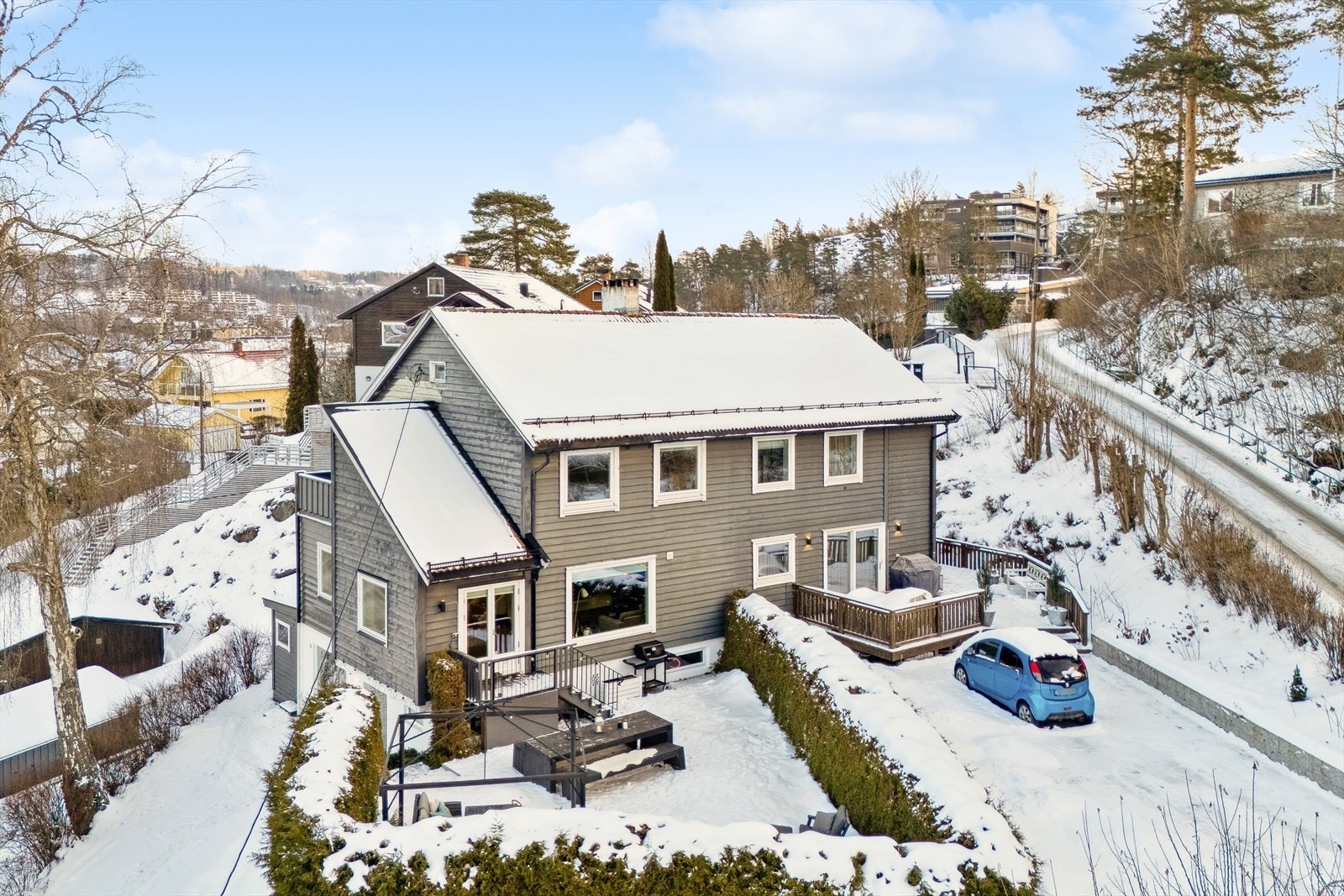 Eiendommen ligger på en nivådelt tomt i skrått terreng, med solide forstøtningsmurer i naturstein som gir et pent og harmonisk uttrykk. Galleribilde