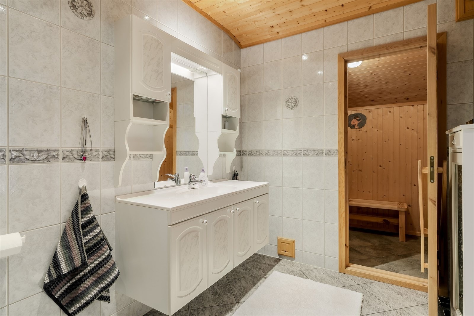 Her er det innredning med god benkeplass og oppbevaring, speilskap, toalett samt dusjløsning. Takhimling i tre gir rommet et lunt preg. Galleribilde