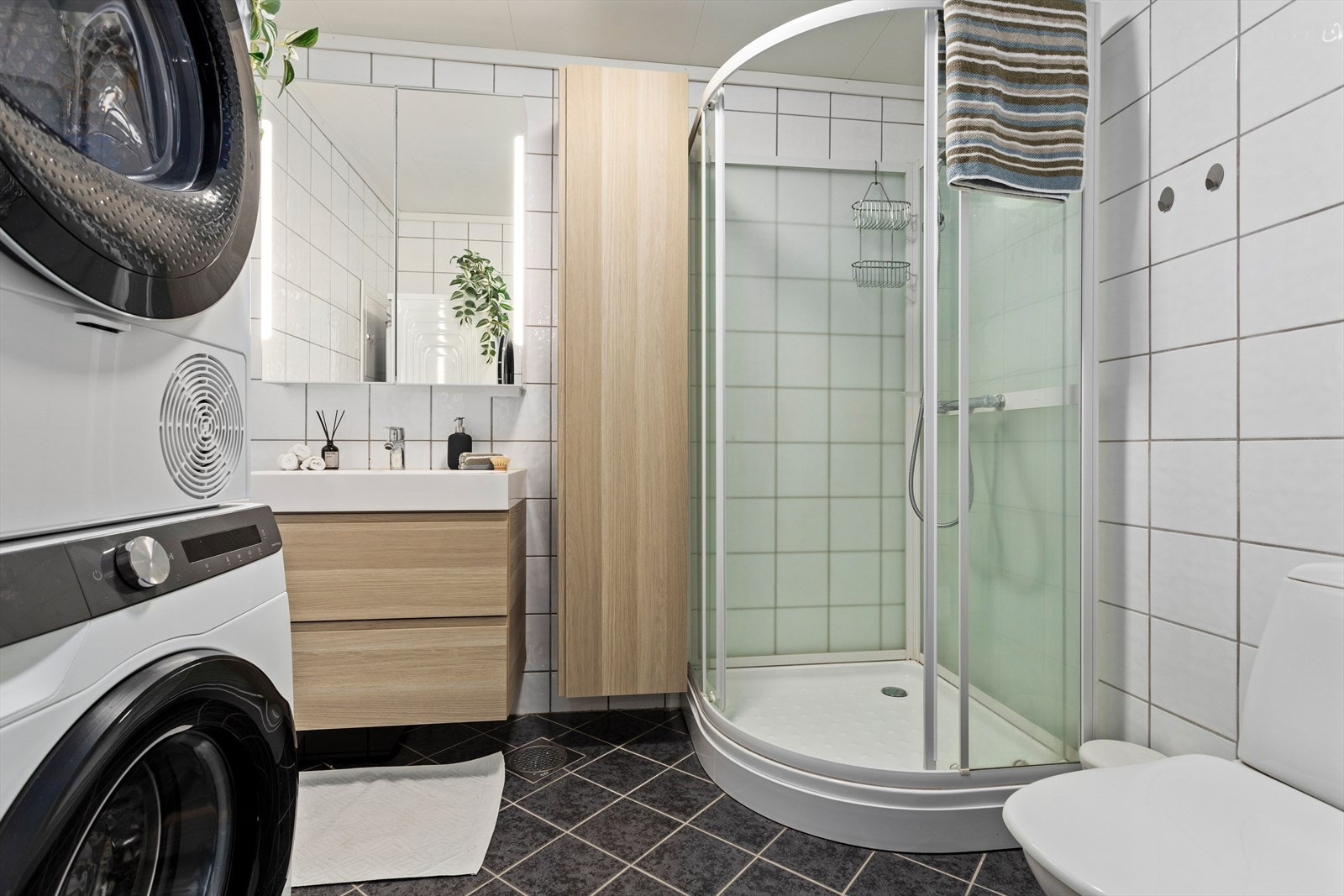 Tidlaust heilflisa bad med varmekablar i golv. Rommet er innreia med opplegg til vaskemaskin, tørketrommel, dusjhjørne, toalett, servant og høgskåp. Det er to slukar på badet. Tørketrommel og vaskemaskin kan følge med i handelen om kjøpar ynskjer. Galleribilde