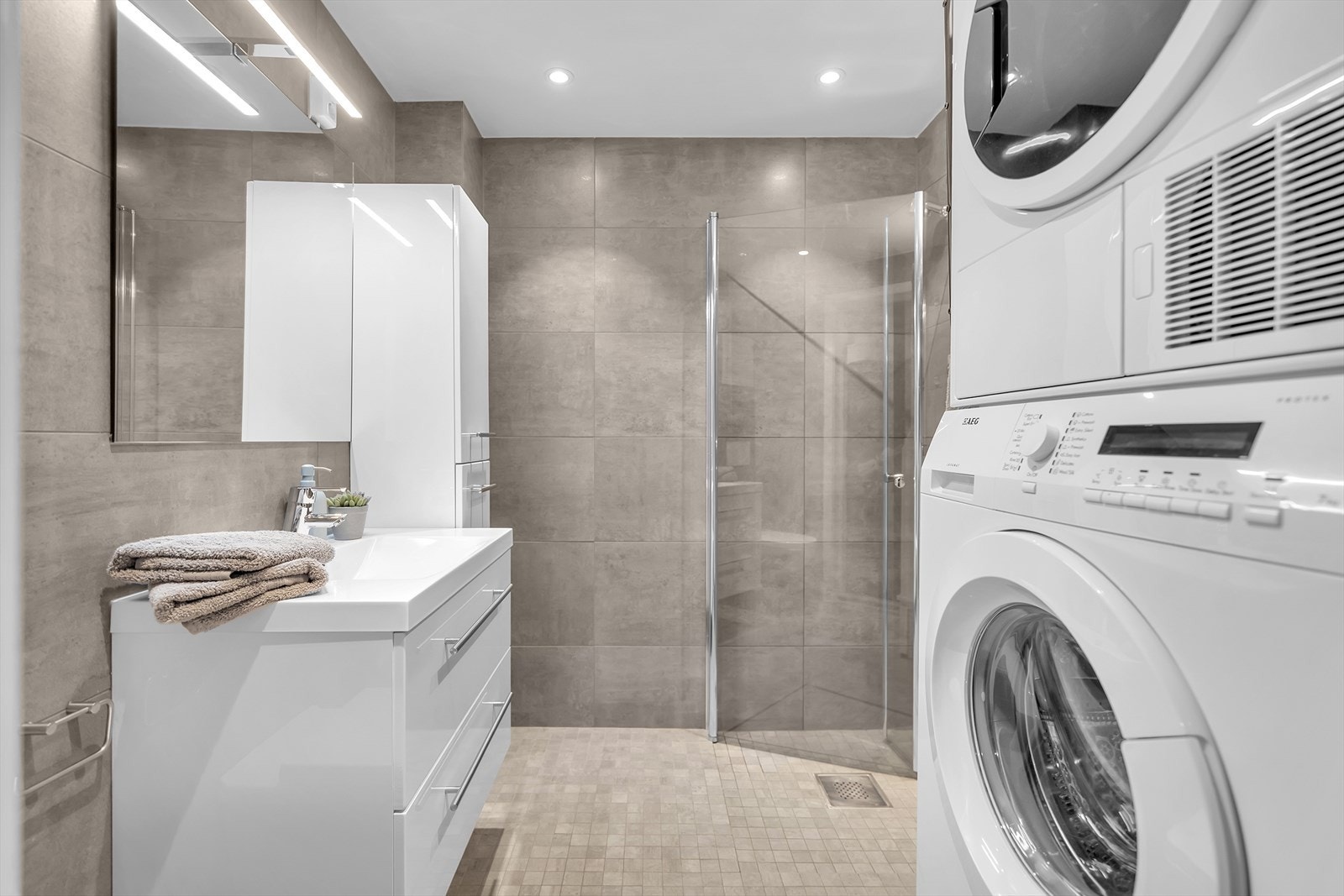 Det vegghengte toalettet bidrar til et minimalistisk og praktisk design. I tillegg er det opplegg til både vaskemaskin og tørketrommel for en praktisk hverdag. Galleribilde